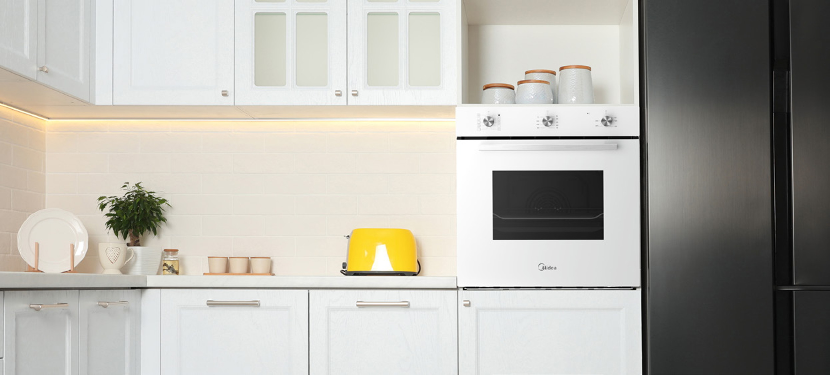 Una cocina moderna con gabinetes blancos, una tostadora amarilla, un horno y un refrigerador negro.