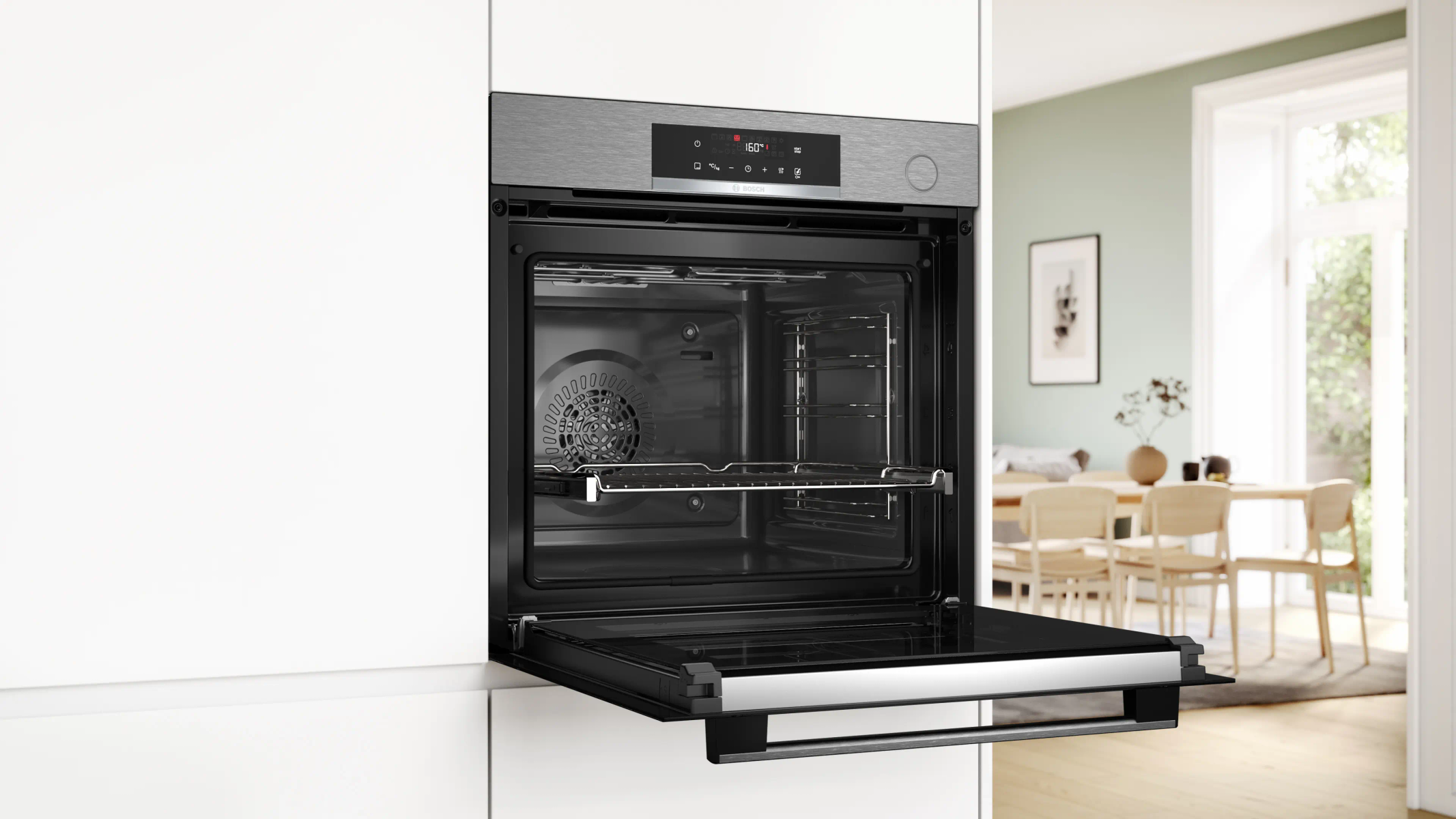 Built-in oven open in a white kitchen. The oven door is open showing shelves.