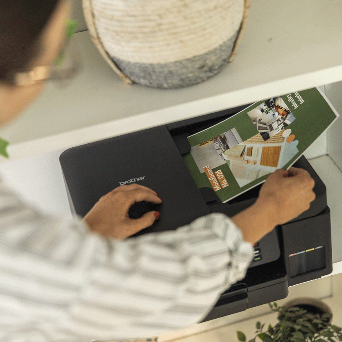 Osoba używa drukarki Brother do wydrukowania dokumentu „Moodboard” w środowisku biurowym.