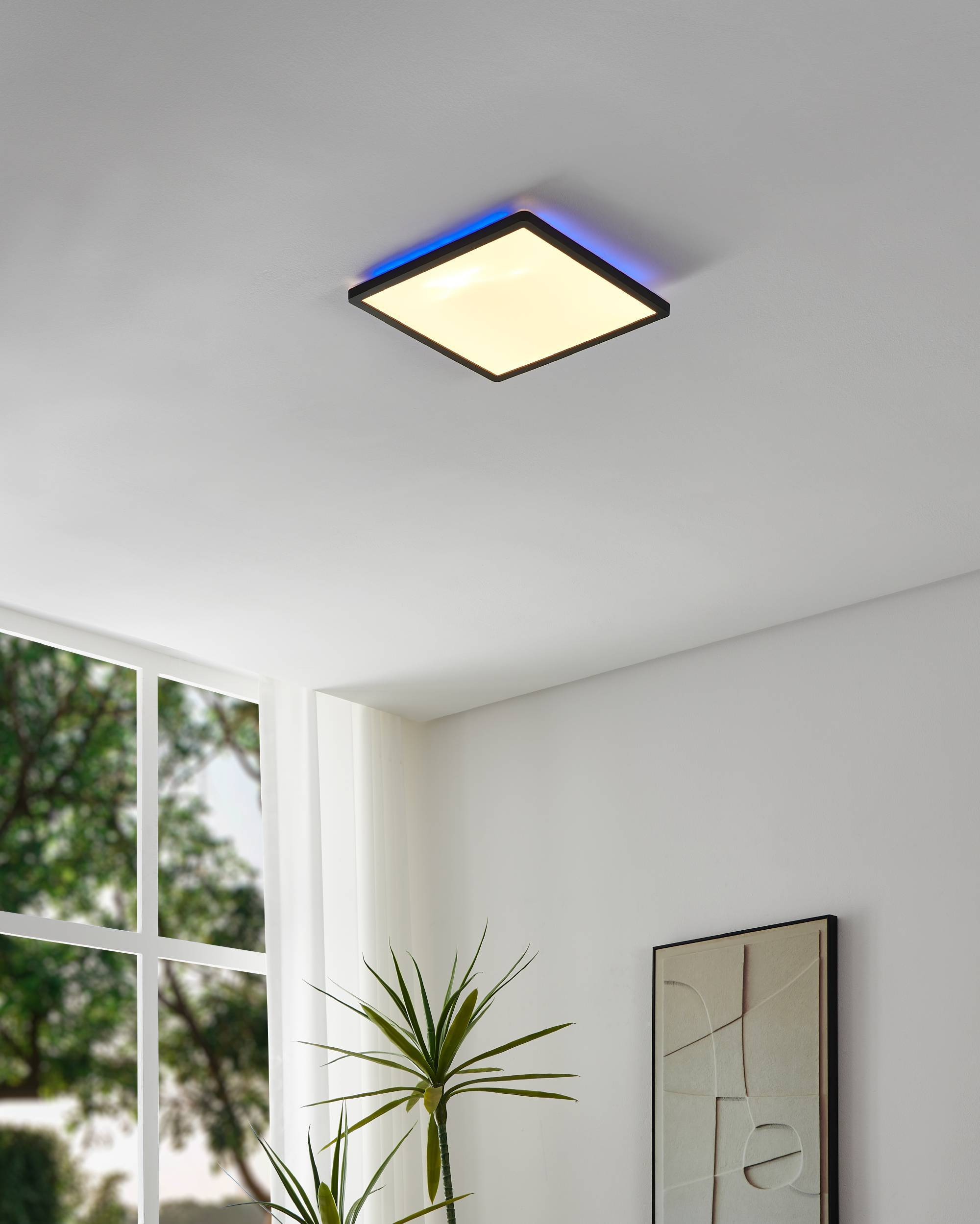 Eine quadratische Deckenleuchte mit schwarzem Rahmen und blauem Licht, installiert in einem Raum mit weißen Wänden.