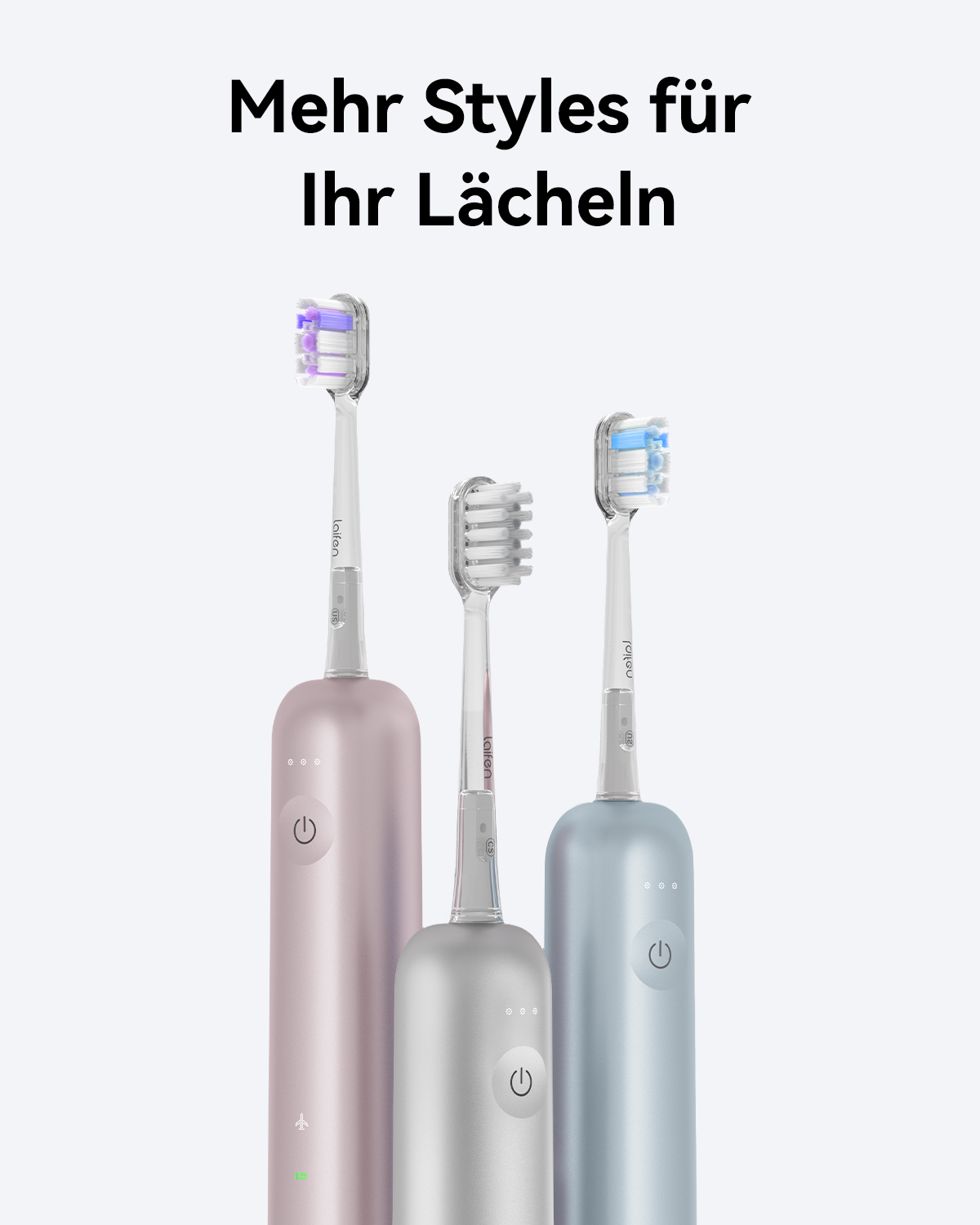 Drei elektrische Zahnbürsten in Rosa, Silber und Blau, mit verschiedenfarbigen Bürstenköpfen, vor weißem Hintergrund.