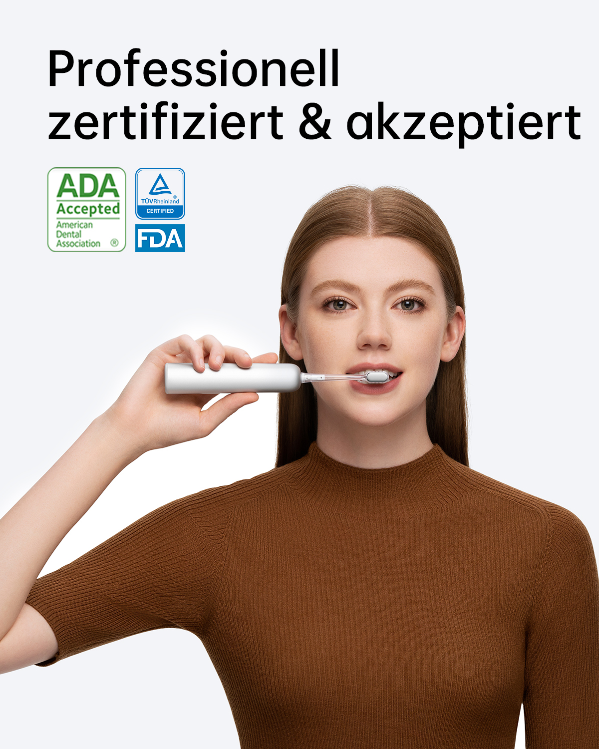 Eine Frau putzt sich mit einer elektrischen Zahnbürste die Zähne. Zwei Logos oben links. Weißer Hintergrund.