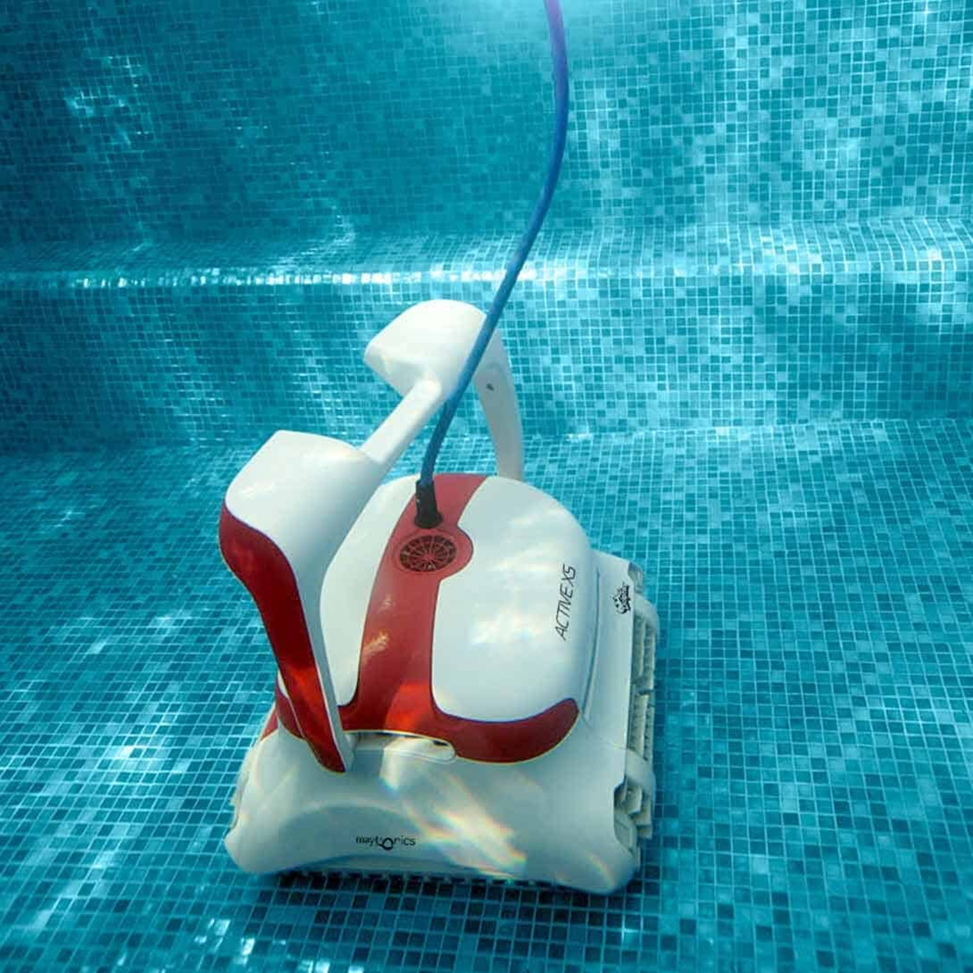 Toma submarina de un limpiador robótico de piscina blanco y rojo. Sumergido en una piscina azul.