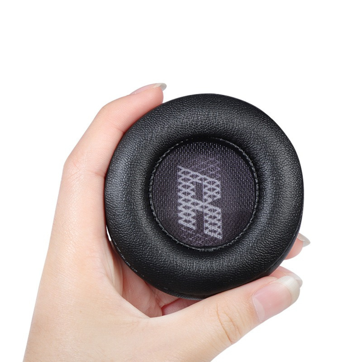 Una mano che tiene un cuscinetto auricolare nero per cuffie, mostrando il dettaglio della rete interna.
