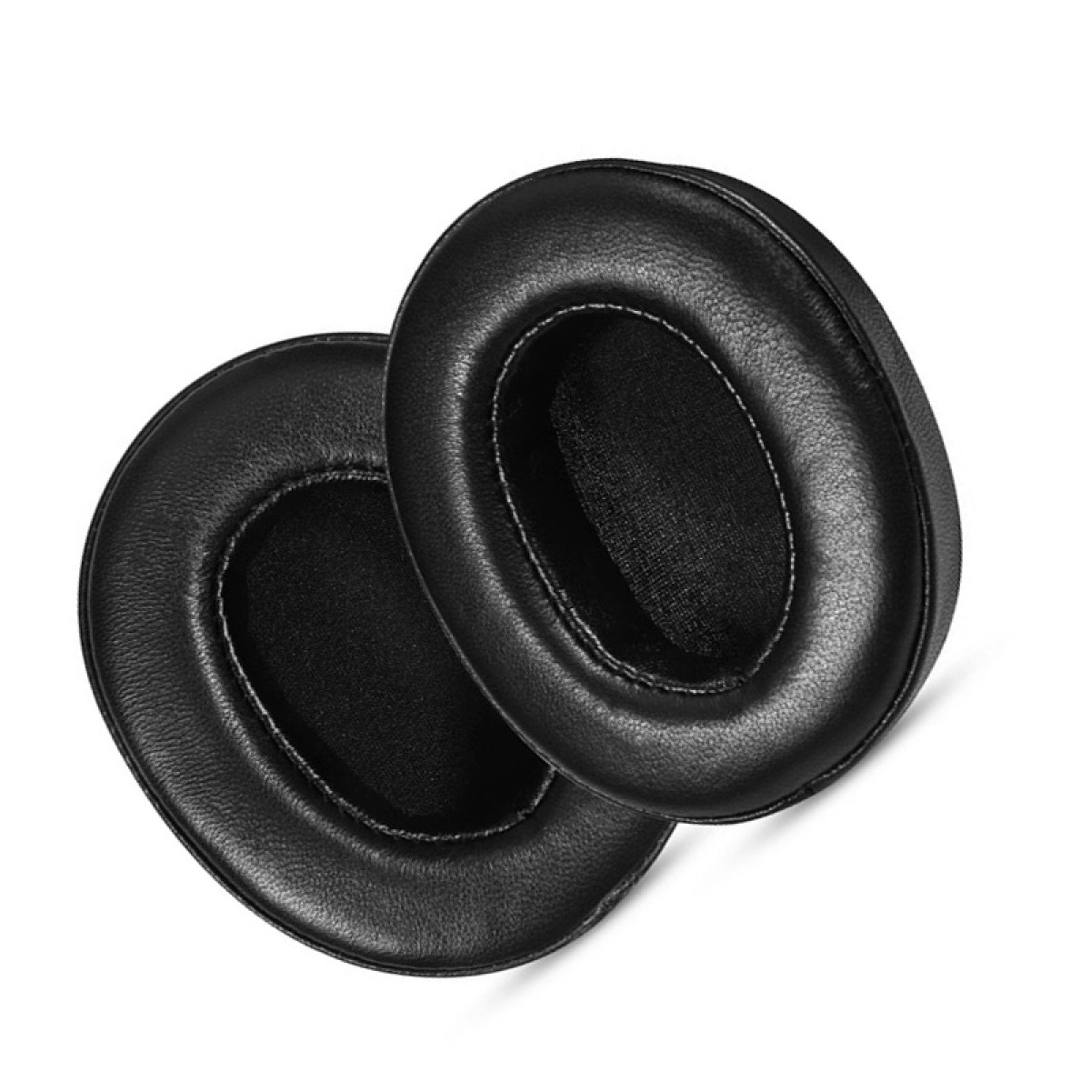 Due cuscinetti auricolari rotondi neri, esposti su una superficie bianca. I cuscinetti hanno una texture liscia, simile alla pelle.