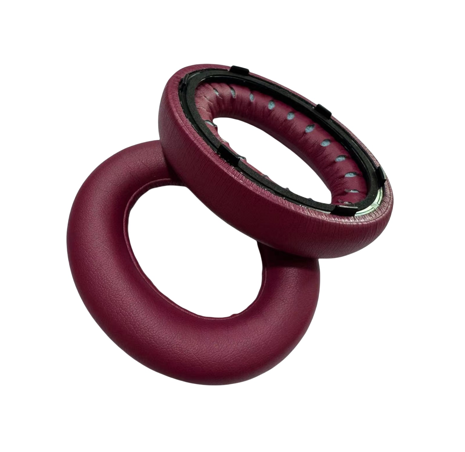 Due cuscinetti auricolari bordeaux, uno sull'altro, su sfondo bianco.