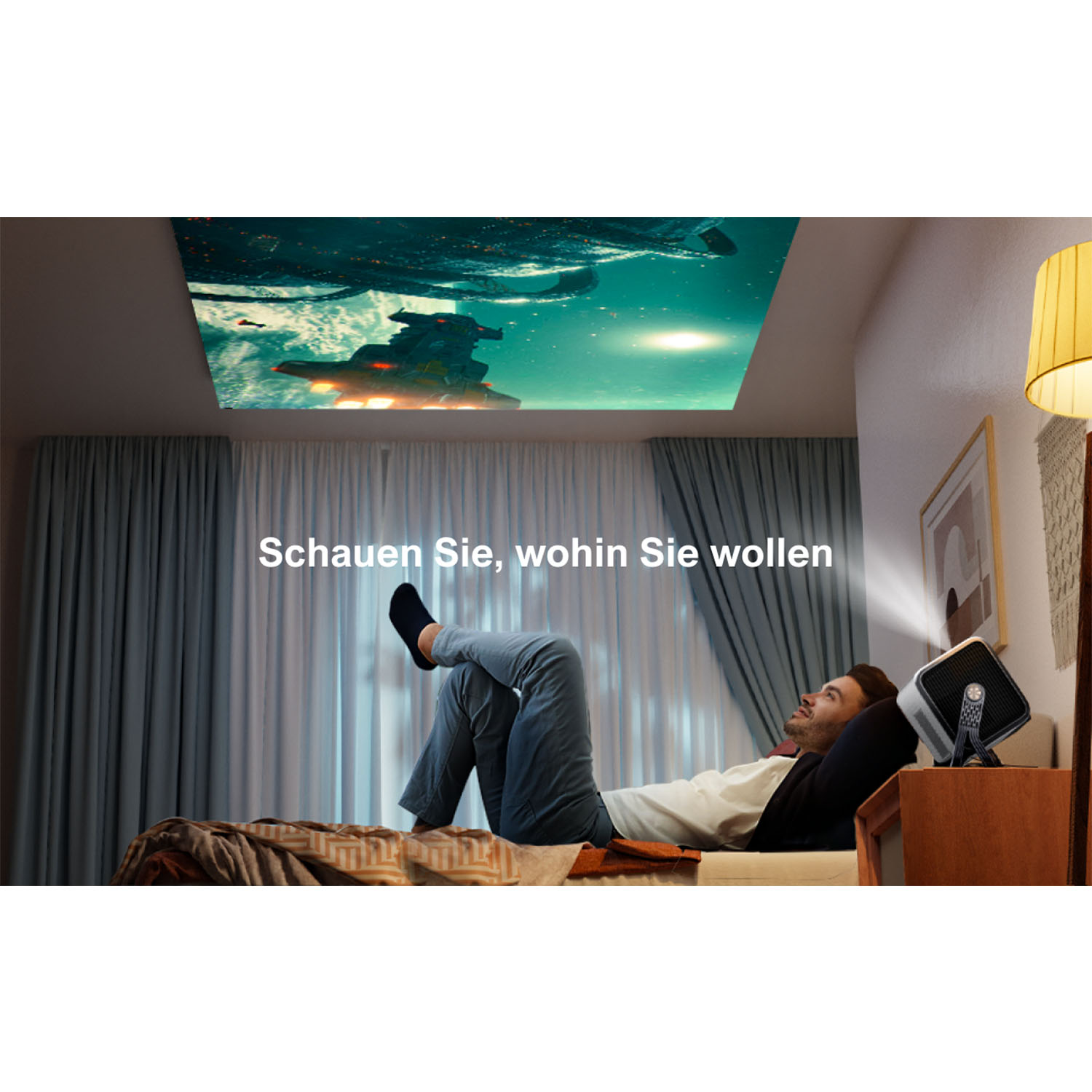 Mann liegt im Bett, schaut projiziertes Bild. Text: 'Schau, wohin du willst'.