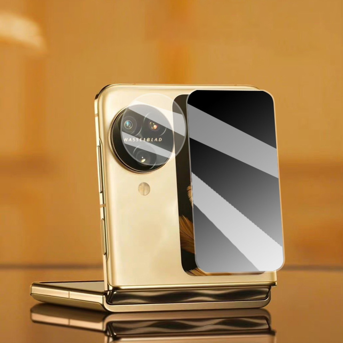 Telefono dorato con protezione schermo e pannello a specchio. Il modulo fotocamera ha il logo Hasselblad.