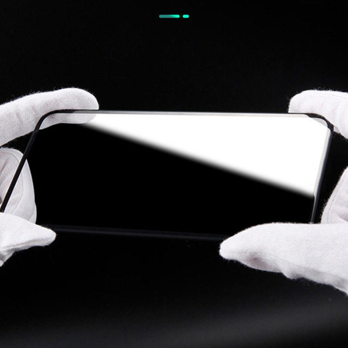 Ein schwarzer Displayschutz, der in Händen gehalten wird. Schwarzer Hintergrund. Der Schutz ist klar und reflektiert Licht.