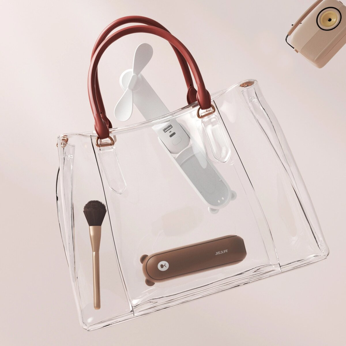 Transparente Tragetasche mit braunen Griffen, mit Ventilator, Make-up-Pinsel und Bärenförmigem Etui.