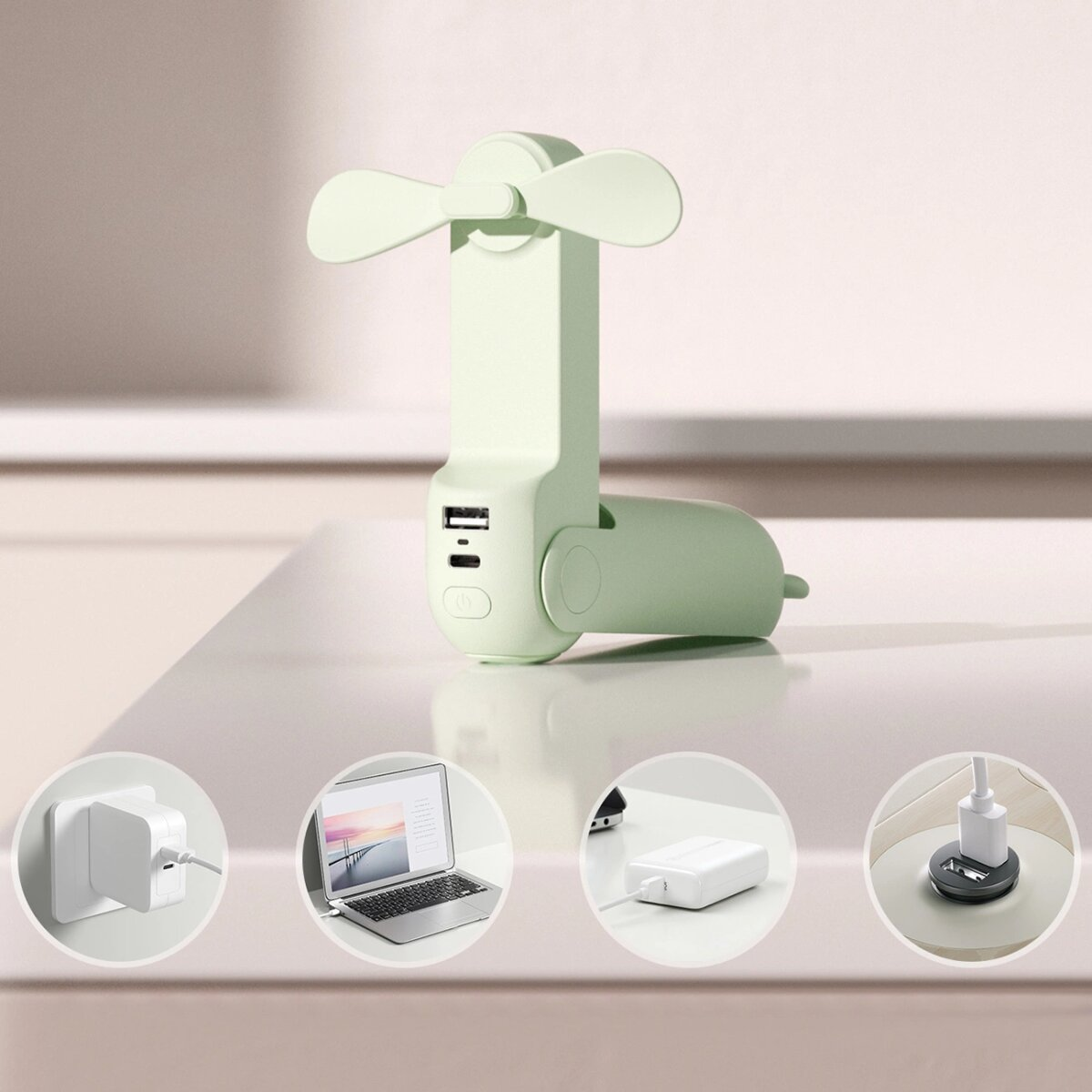 Grüner tragbarer Ventilator mit USB-Anschlüssen und Laptop, Ladegeräte in Kreisen auf einem Tisch.