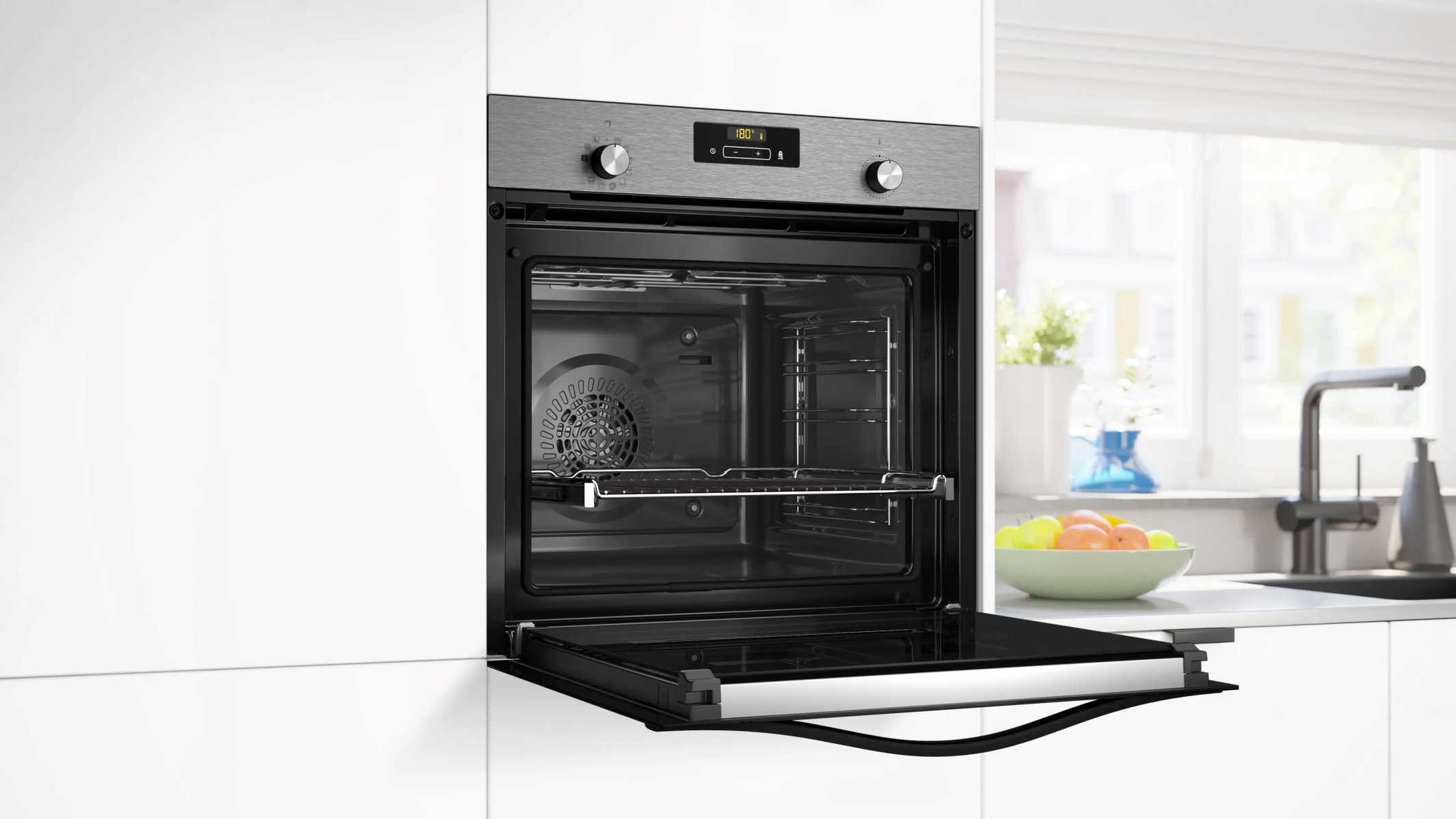 Otwarty piekarnik w kuchni, z wyświetlaczem cyfrowym, w szafce kuchennej.