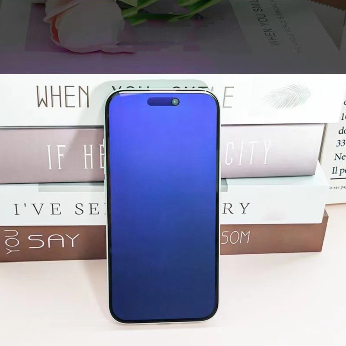 Niebieski telefon stoi oparty o książki, prezentując elegancki i nowoczesny design.