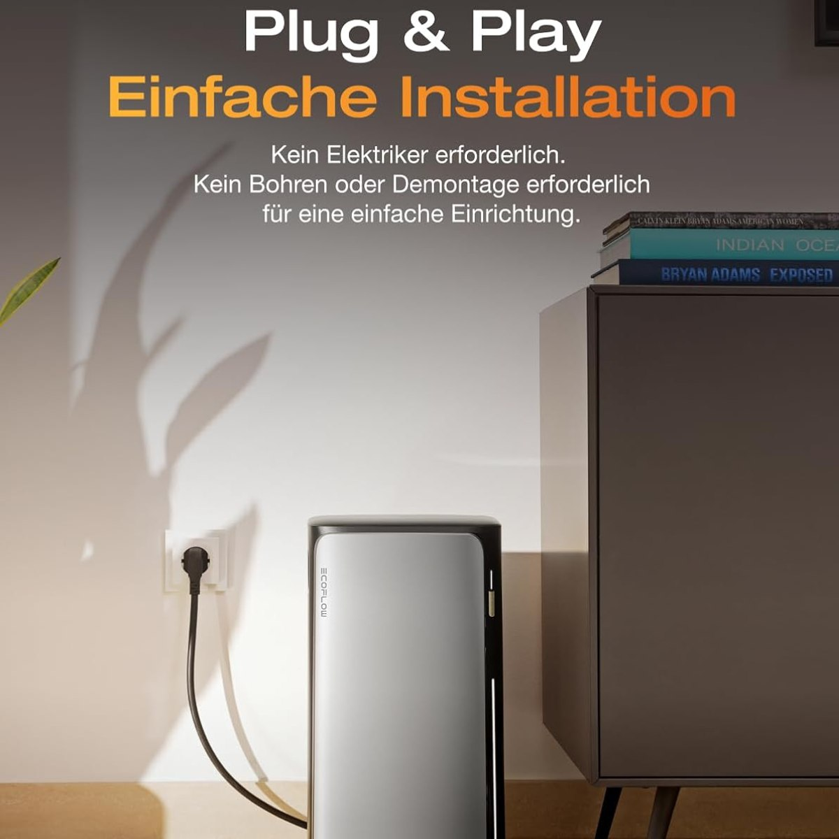 Eine Steckdose mit einem eingesteckten Kabel, neben einem schwarzen Gerät und einem Bücherstapel.