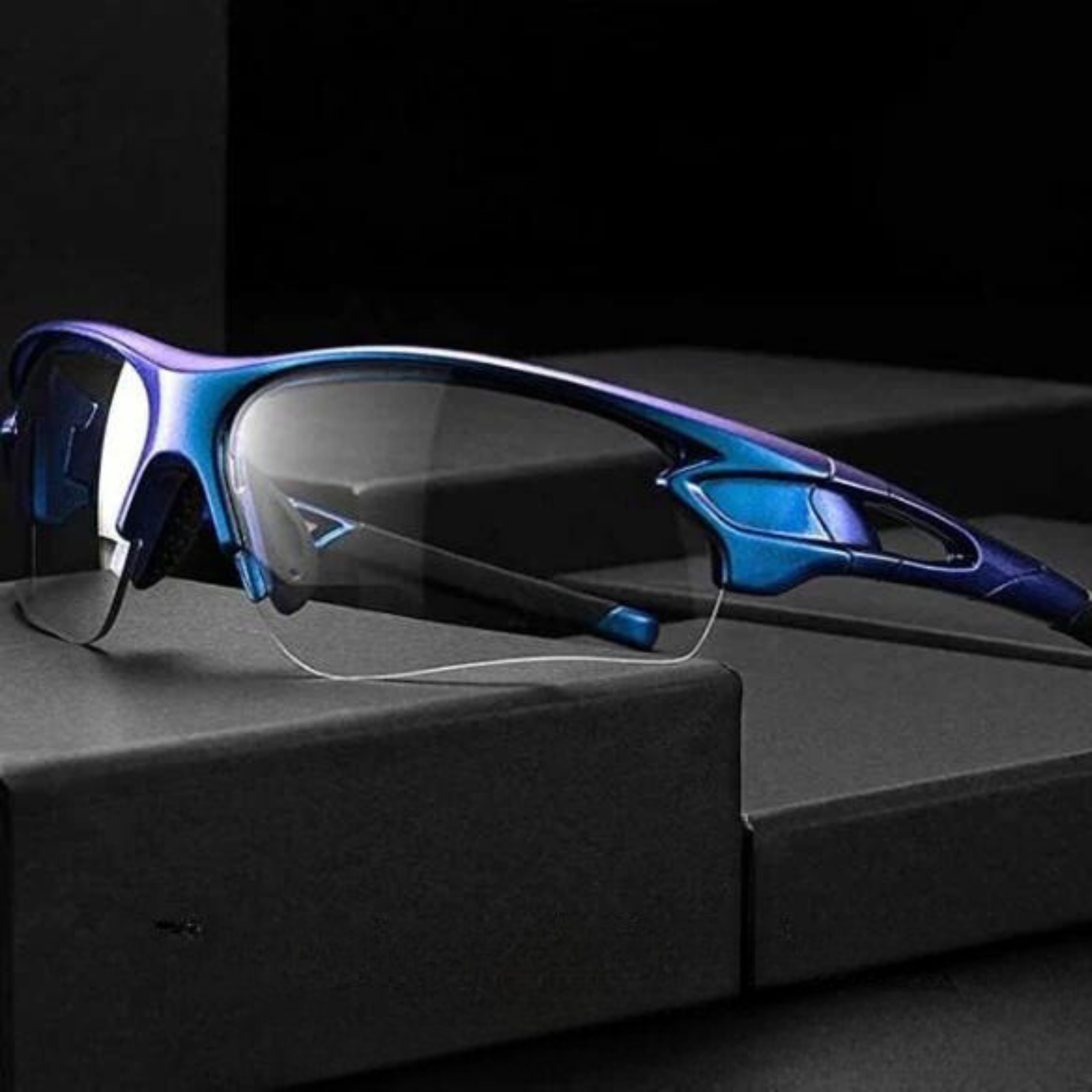 Blaue und violette Sportsonnenbrille auf schwarzer Oberfläche. Sie hat klare Gläser und ein schlankes Design. Der Hintergrund ist dunkel.