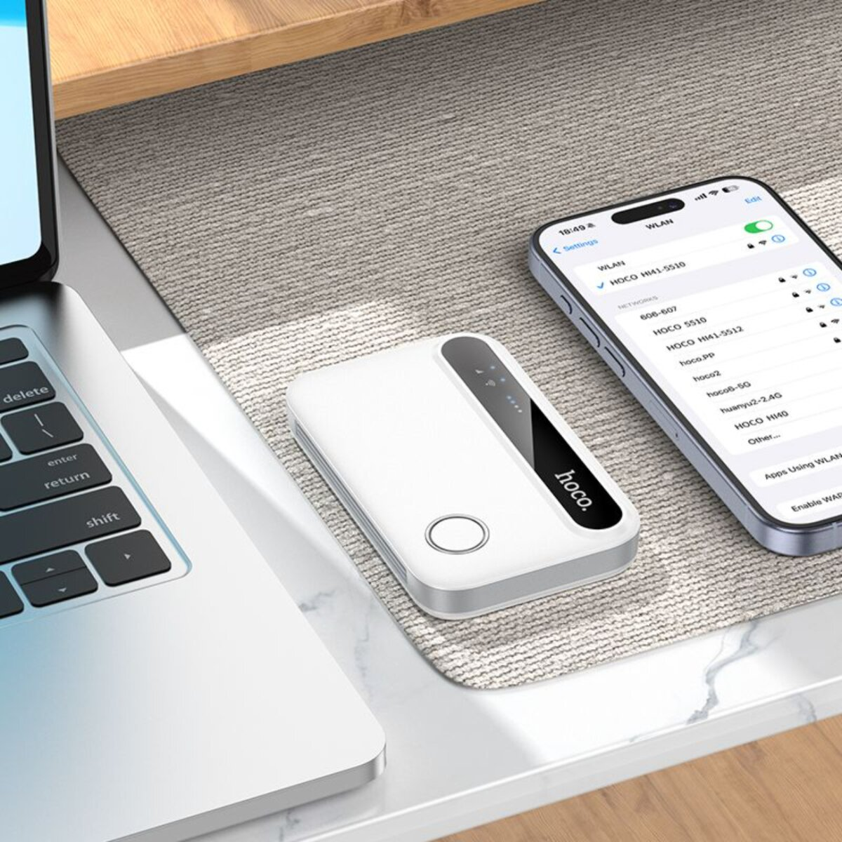 Un dispositivo hoco. bianco con uno smartphone e un laptop su una scrivania. Il dispositivo è al centro.