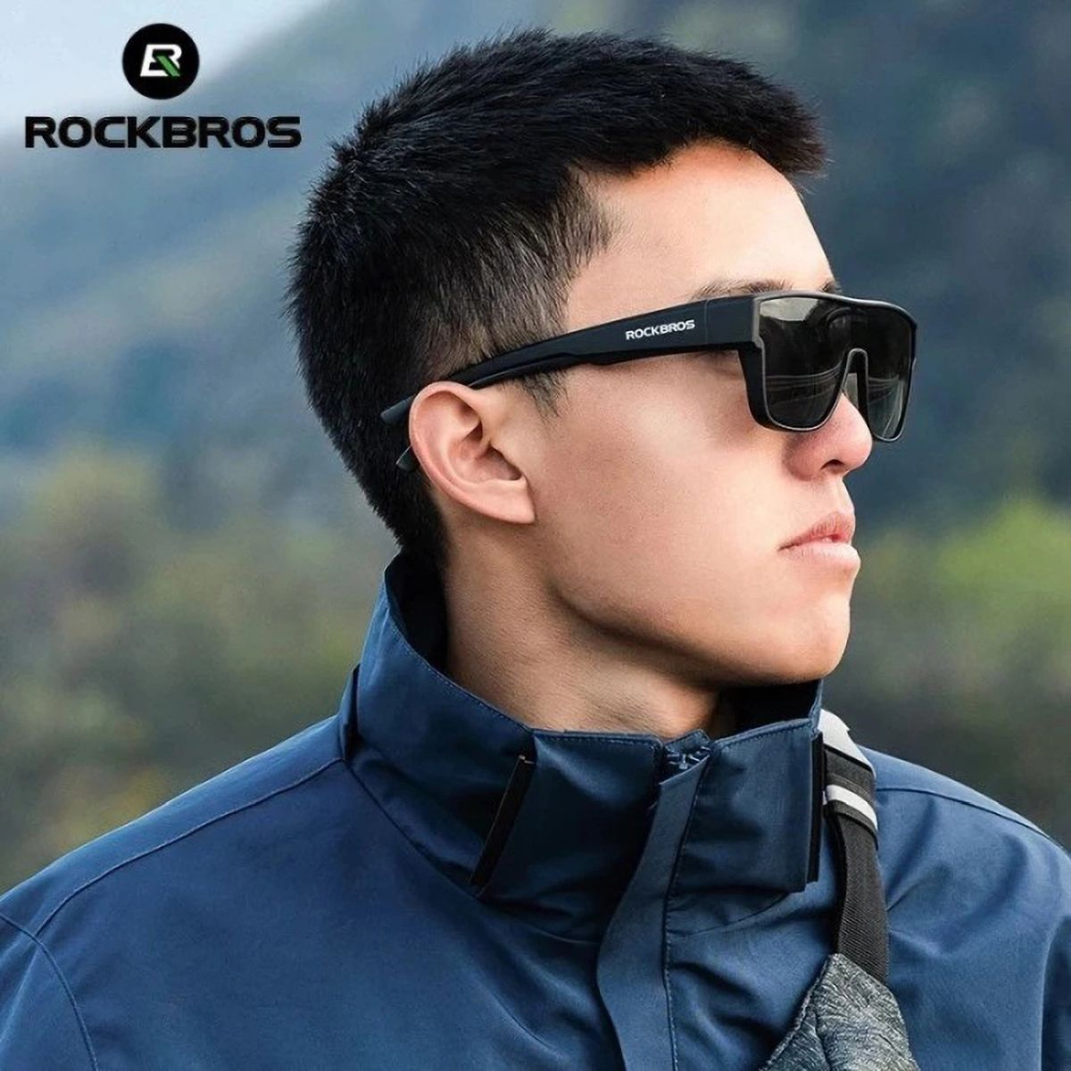 Ein Mann mit Sonnenbrille mit schwarzem Rahmen und dunklen Gläsern, die Marke ROCKBROS ist auf der Seite.