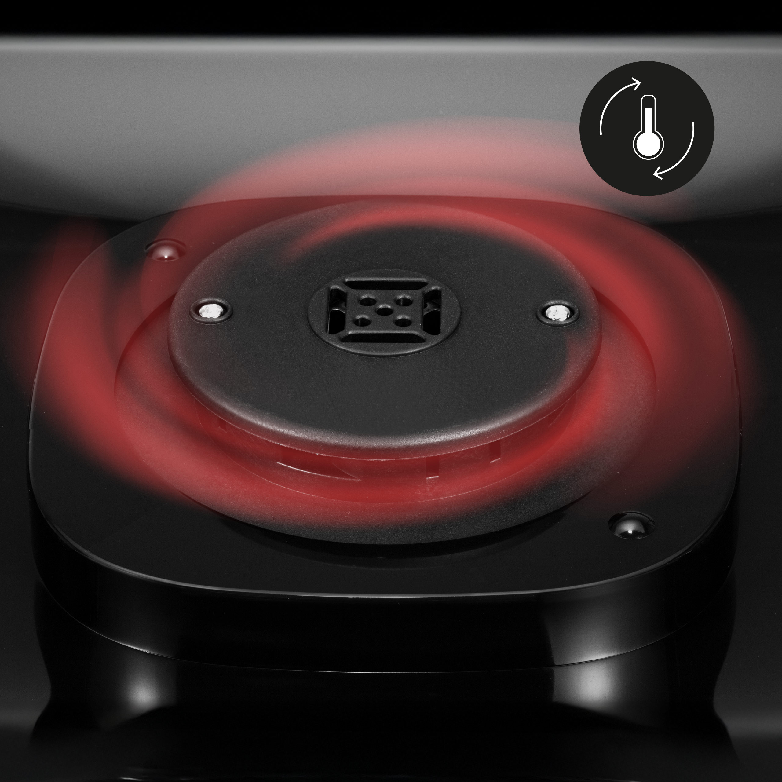 Zbliżenie czarnej płyty indukcyjnej z czerwonym świecącym pierścieniem i ikoną termometru wskazującą temperaturę.