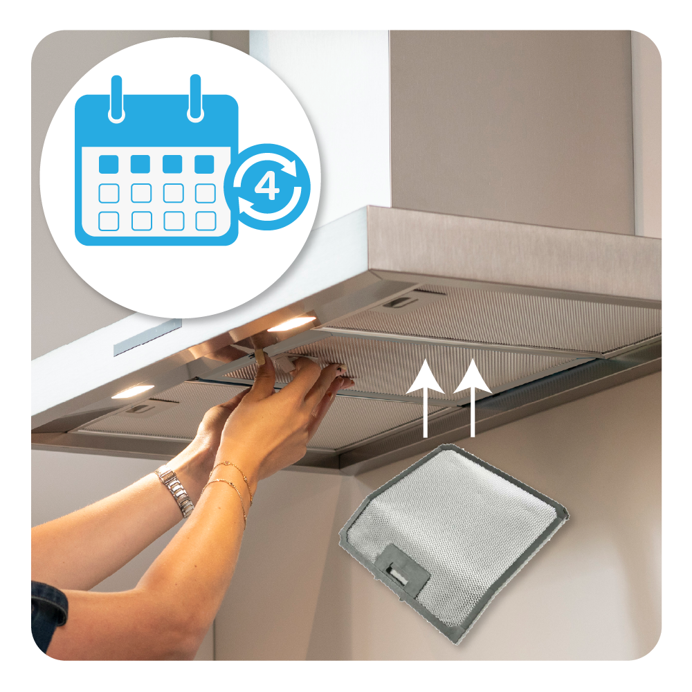Le mani installano un filtro metallico rettangolare in una cappa aspirante in acciaio inossidabile.