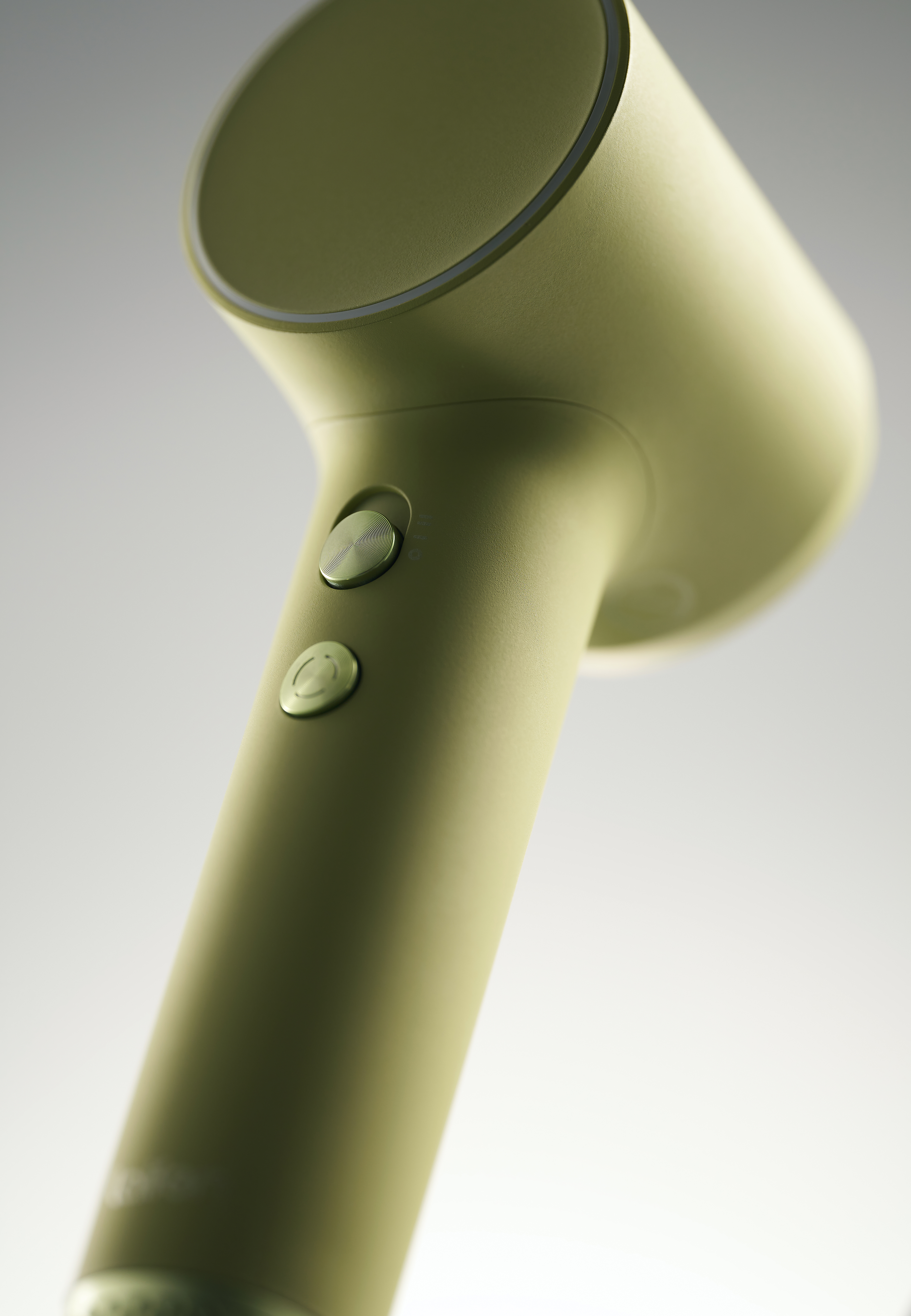 Close-up van een groene föhn, die de cilindrische kop en handgreep laat zien, waarbij het ontwerp en de kleur worden benadrukt.