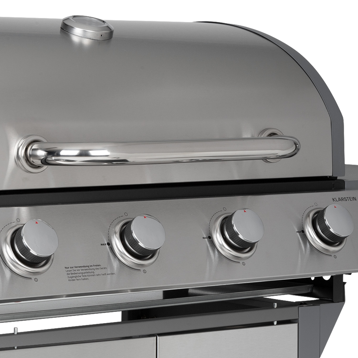 Nahaufnahme eines Edelstahlgrills mit vier Knöpfen, einem Griff und einem Deckel.