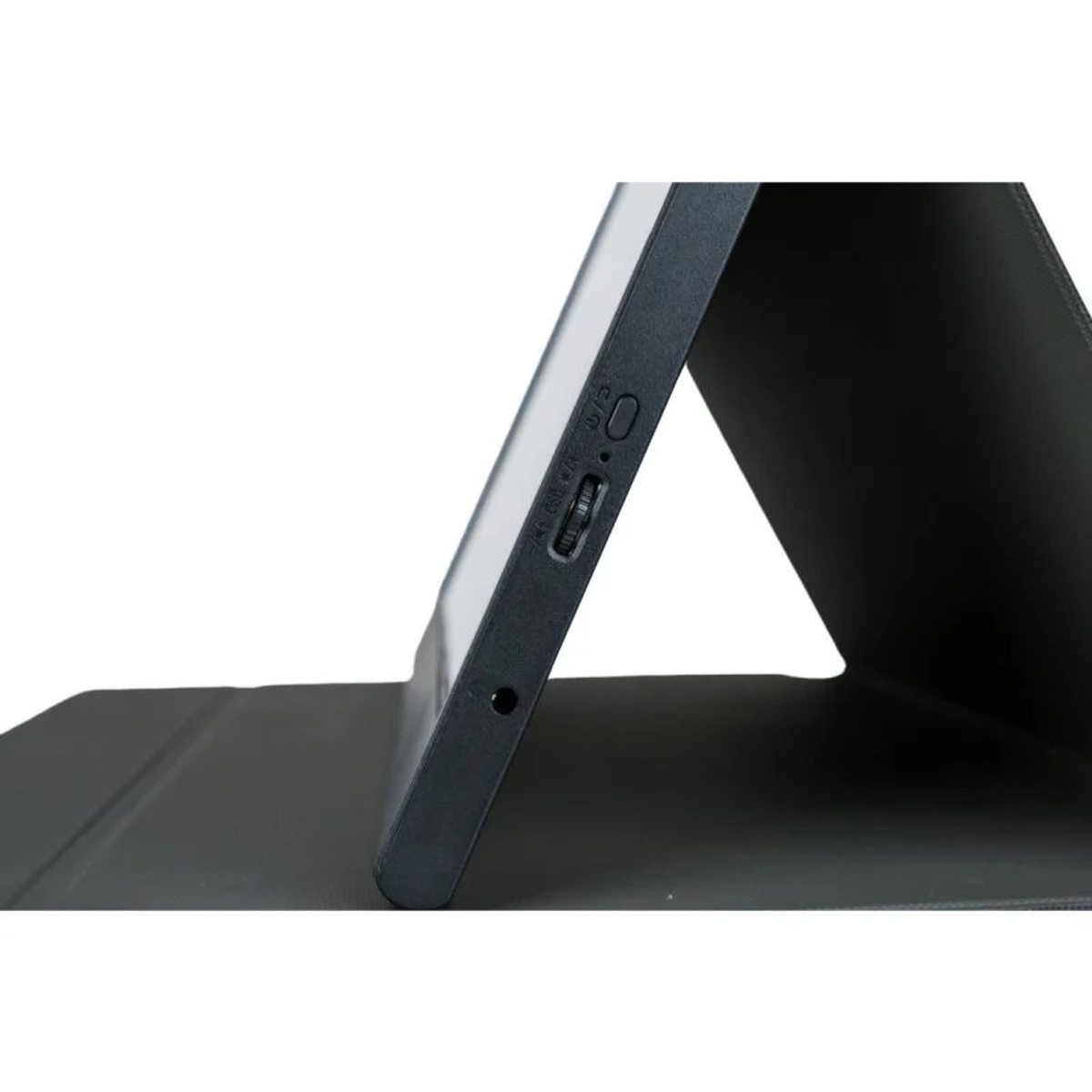 Primer plano del lateral de un monitor portátil negro. Muestra puertos y botones. La cubierta está en primer plano.