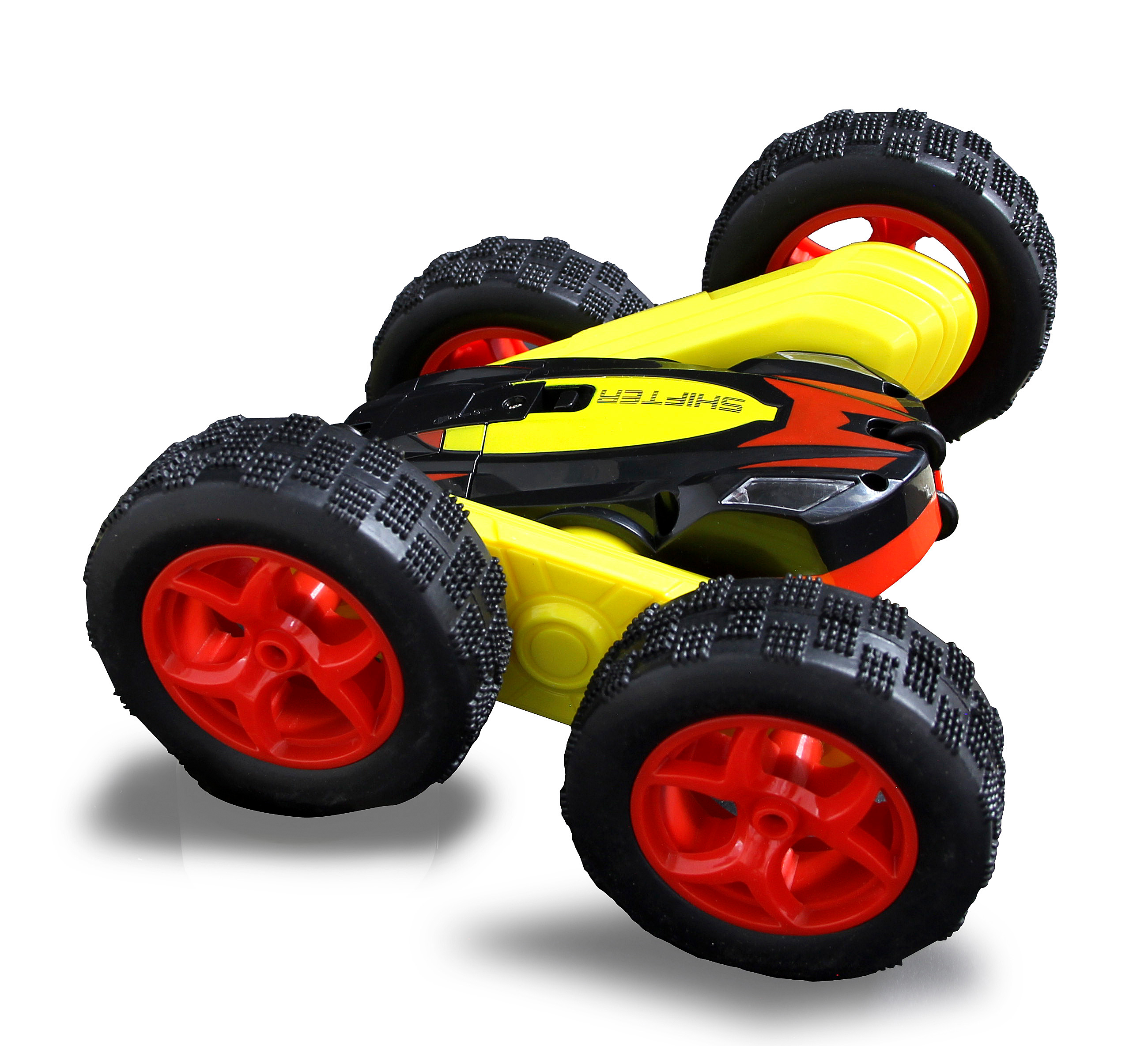 Ein gelbes, schwarzes und rotes Spielzeugauto ist abgewinkelt, wobei die Räder nach oben zeigen. Das Auto befindet sich auf weißem Hintergrund.