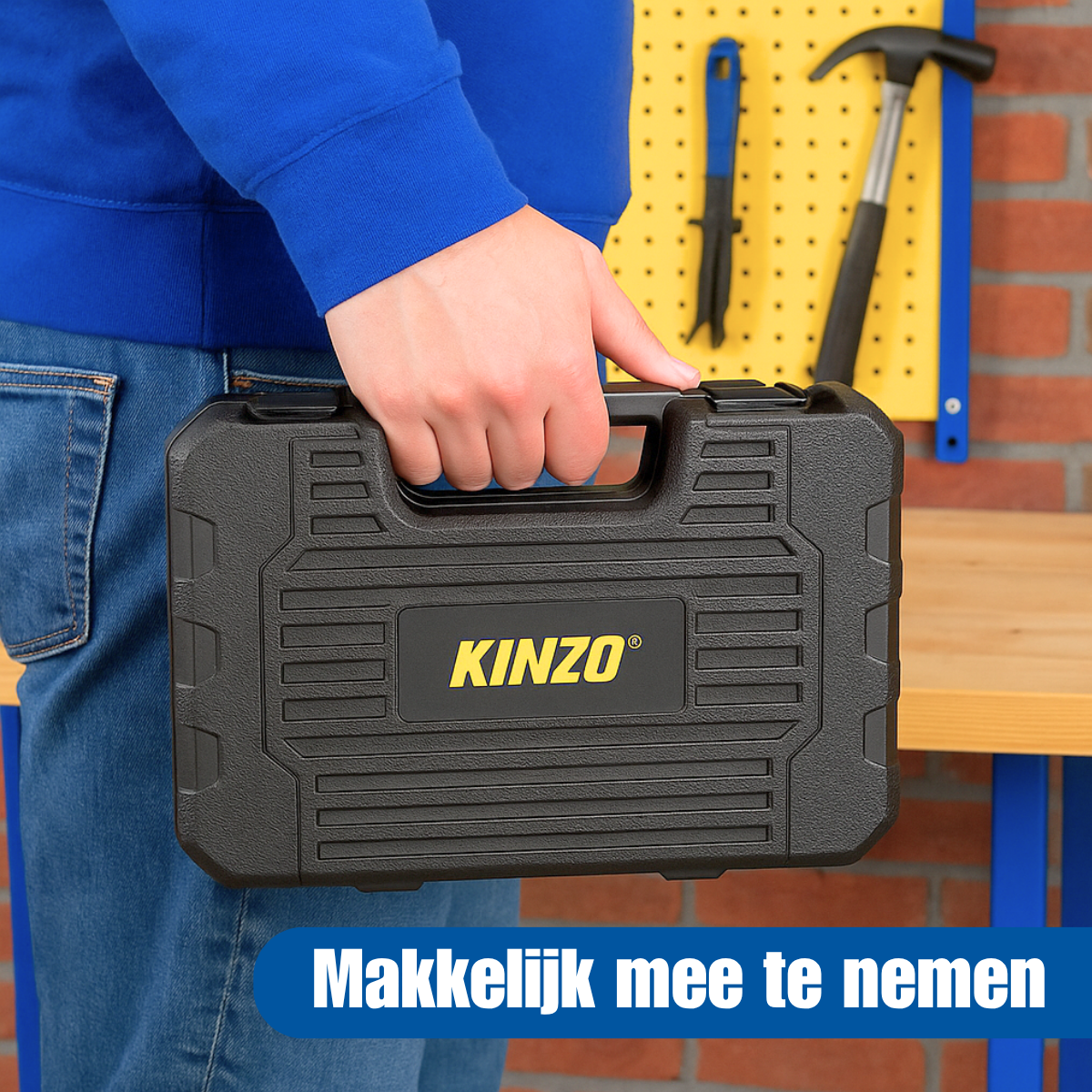 Een persoon die een zwarte gereedschapskist met het label 'KINZO' vasthoudt voor een bakstenen muur met gereedschap.