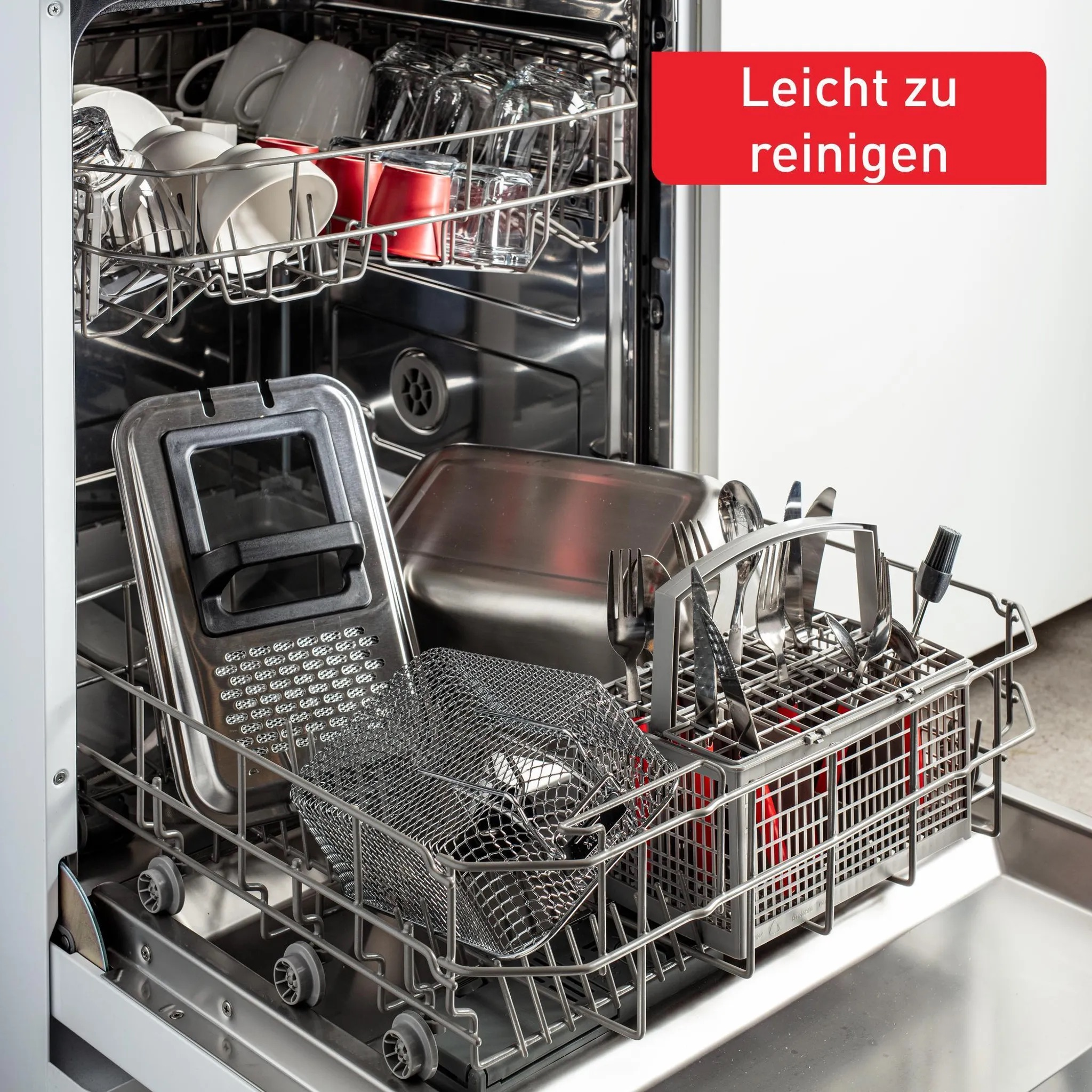 Zmywarka wypełniona naczyniami, szklankami i sztućcami. Na górze czerwony tekst 'Łatwe do czyszczenia'. Maszyna jest otwarta.