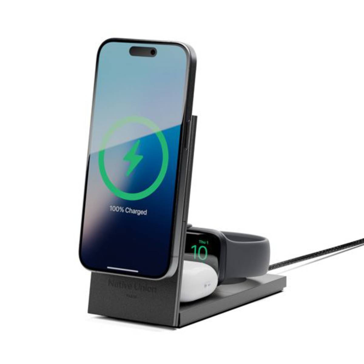 Ein Telefon, das auf einem Ständer geladen wird und 100 % geladen anzeigt. Eine Apple Watch und Ohrhörer.