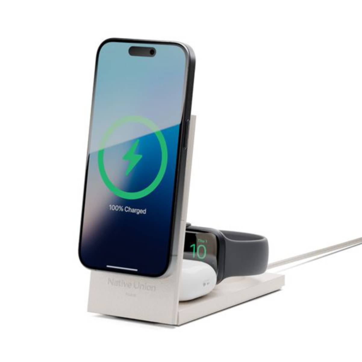 Ein Telefon, das auf einem Ständer geladen wird und 100 % geladen anzeigt. Eine Apple Watch und Ohrhörer.