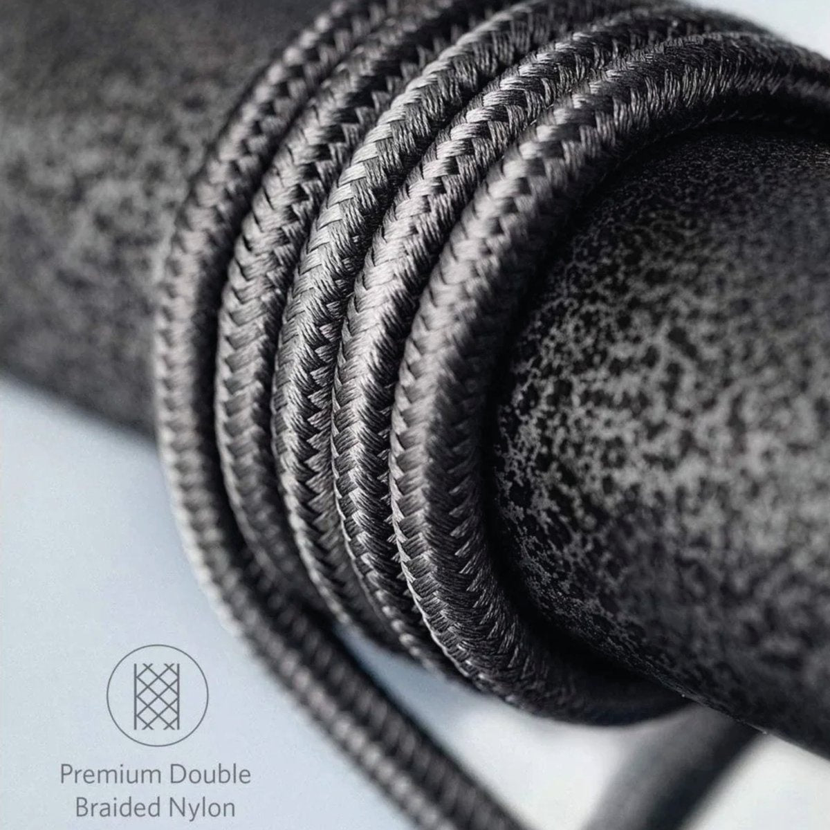 Close-up of a black braided nylon cable. The cable is coiled, showing the texture and the words 'Premium Double Braided Nylon'.