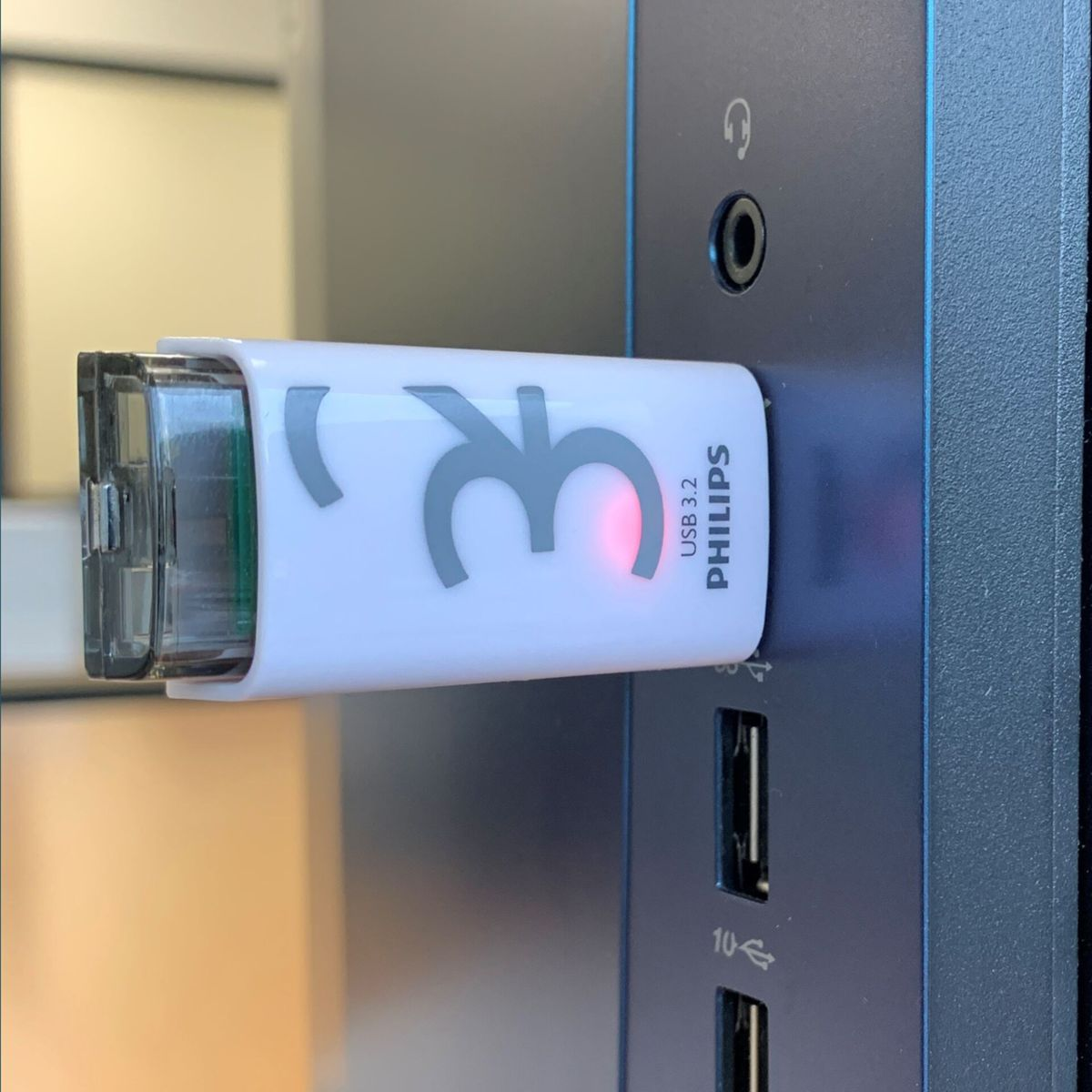 Biały i szary pendrive podłączony do komputera. Philips USB 3.2 jest na nim napisane.