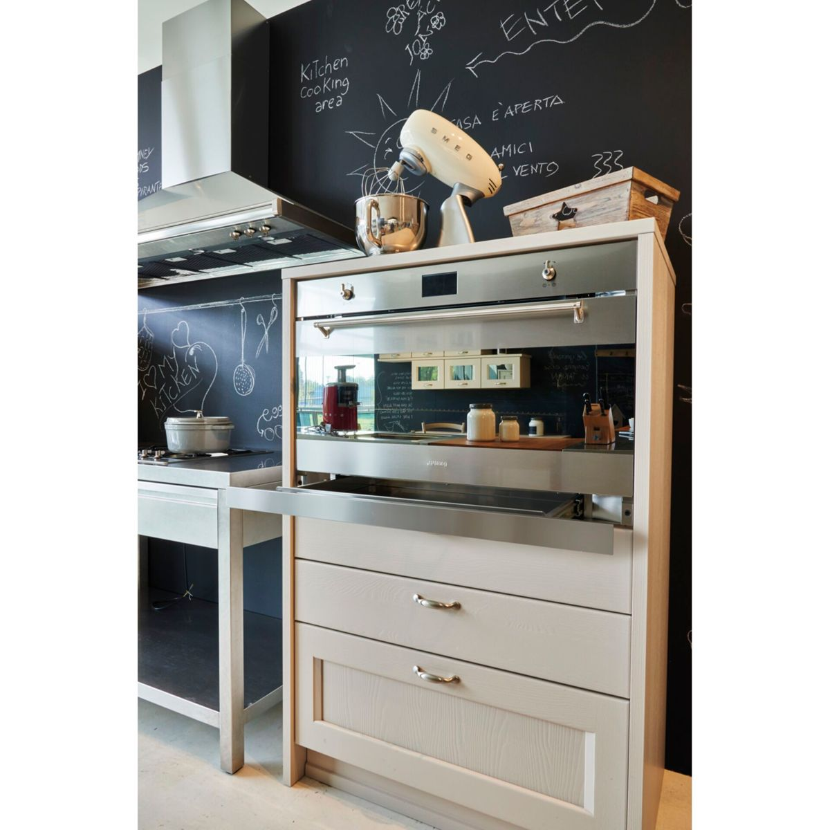 Una cucina moderna con forno a incasso e cassetti. Un frullatore in alto e una lavagna dietro.