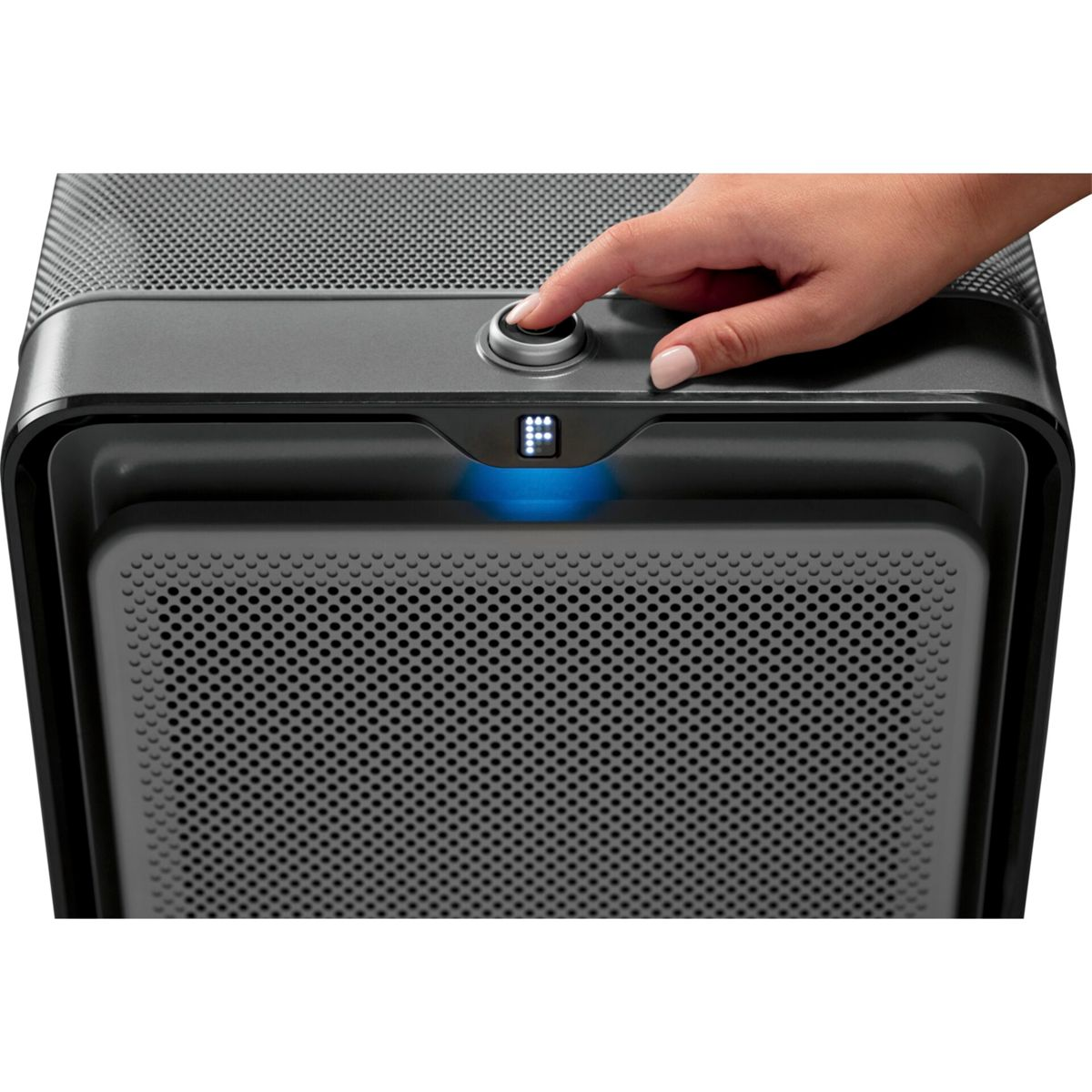Una mano preme un pulsante su un purificatore d'aria nero. Il display mostra una luce blu e la lettera 'P'.