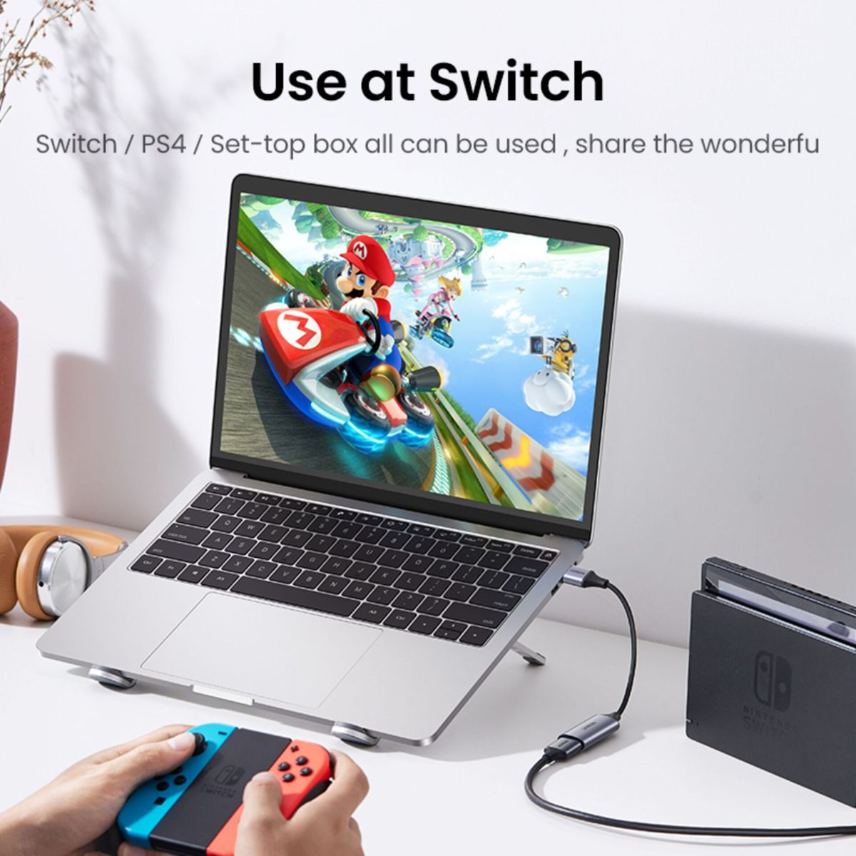 Ein Laptop, der über einen USB-C-Adapter mit einer Nintendo Switch verbunden ist, mit Controllern.