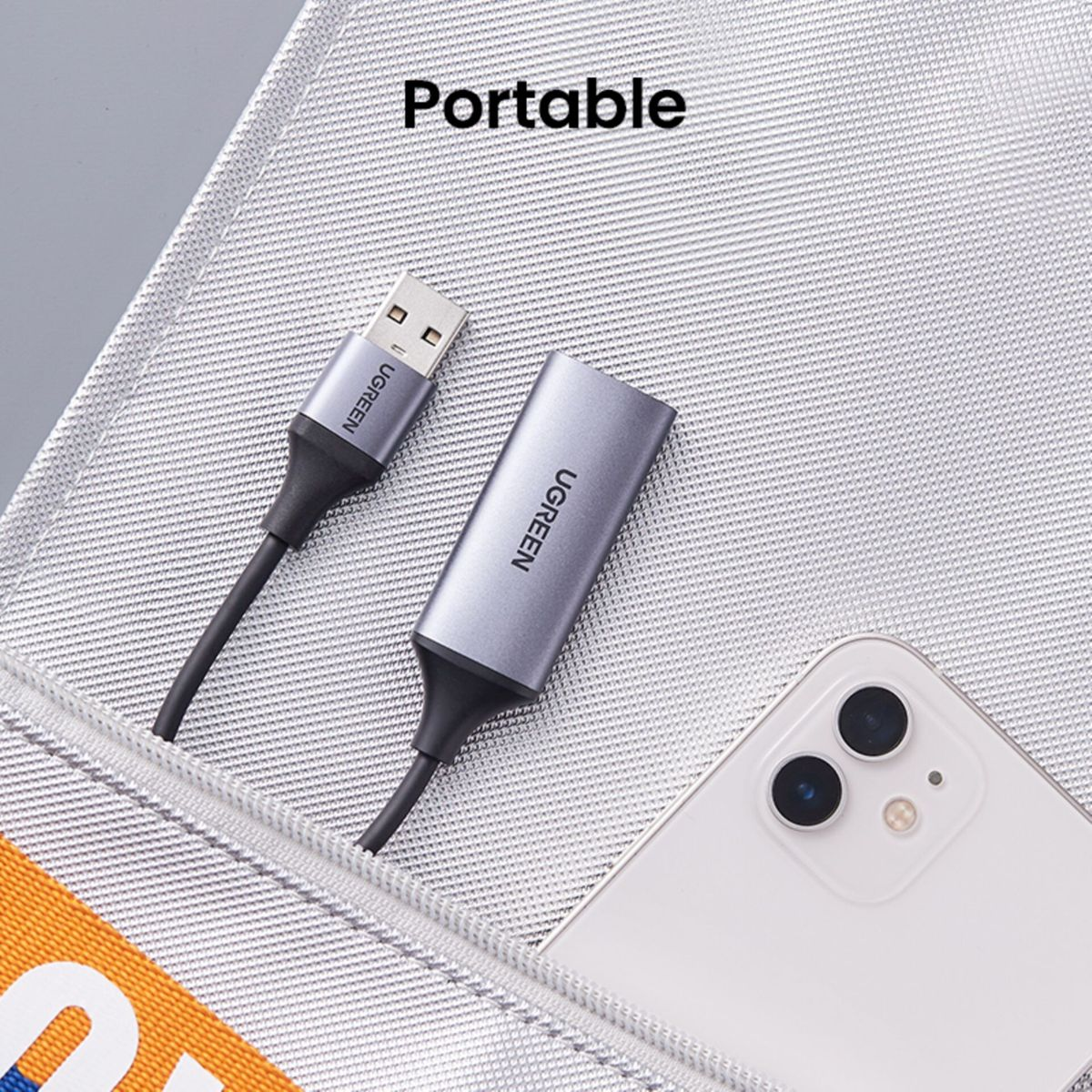 Weißes Telefon und grauer USB-C-Adapter. Der Adapter ist mit dem Telefon verbunden. Im Hintergrund steht 'Portable'.