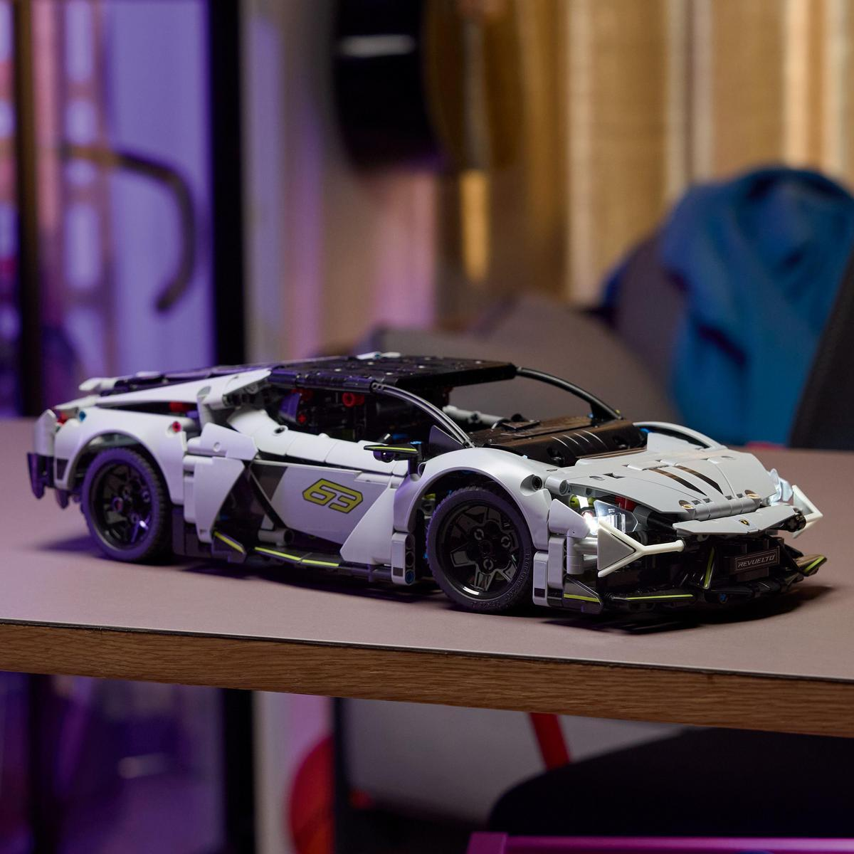 Biały model Lego Lamborghini Sián FKP 37 z czarnymi detalami, na stole, z fioletowym oświetleniem.
