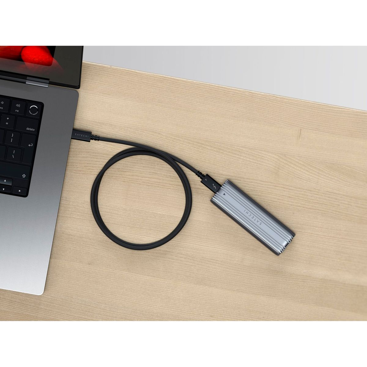 Laptop collegato a disco rigido esterno e monitor. Il laptop è su un tavolo di legno. Disco rigido argento.