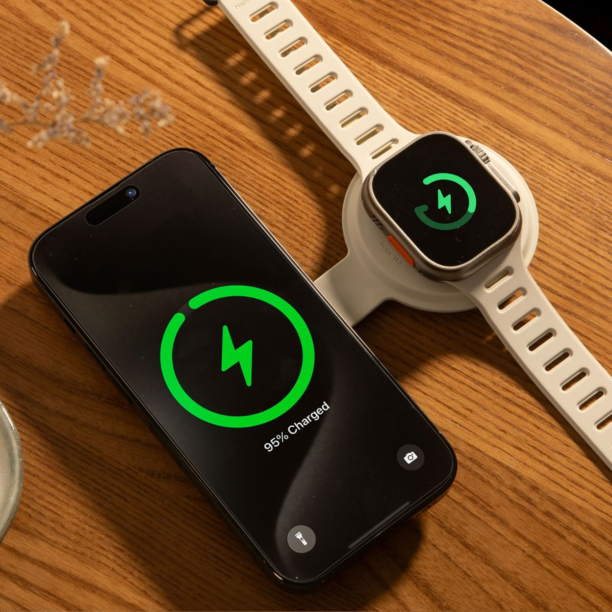 Ein Telefon und eine Smartwatch werden aufgeladen. Das Telefon zeigt 95 % geladen. Die Uhr zeigt ein grünes Ladesymbol.