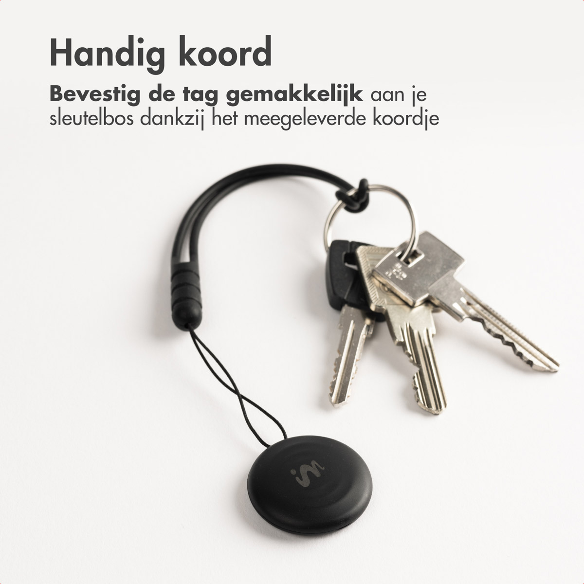 Black tag attached to keys via a string. Text 'Handig koord' above. Text in Dutch below