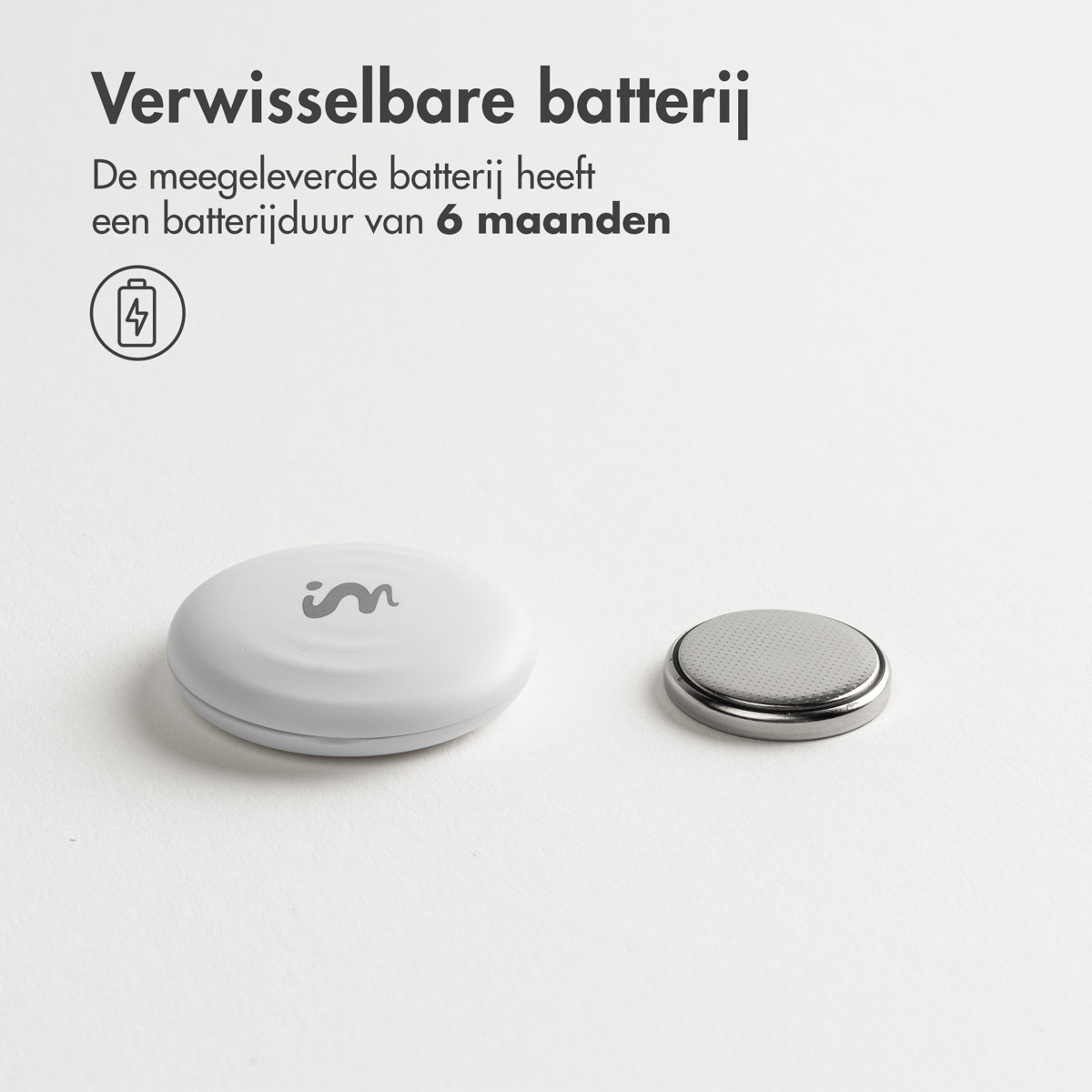 White tag and battery. Text 'Verwisselbare batterij'. Battery has 6 months duration.