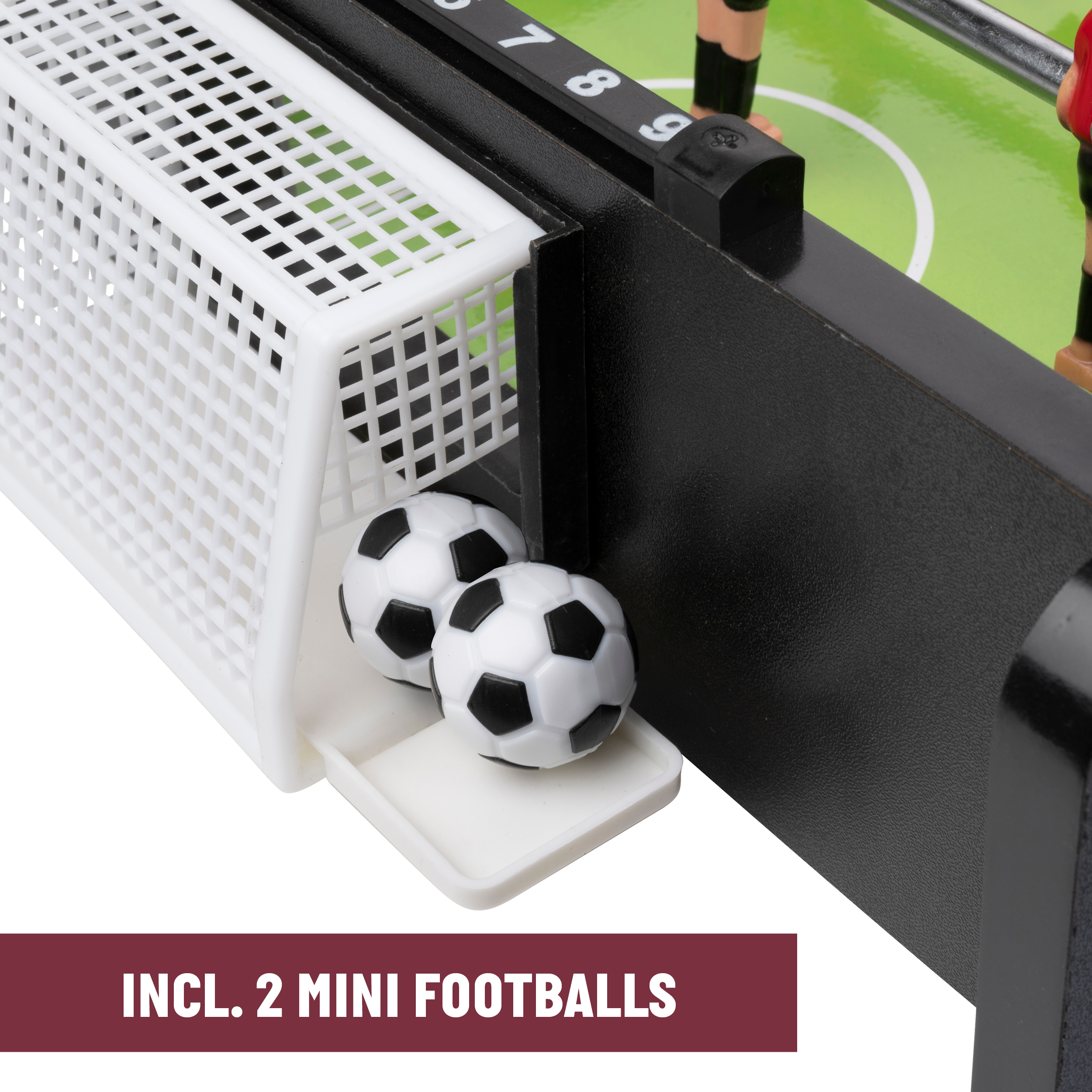 Close-up of a foosball table goal with two miniature soccer balls inside a white net.