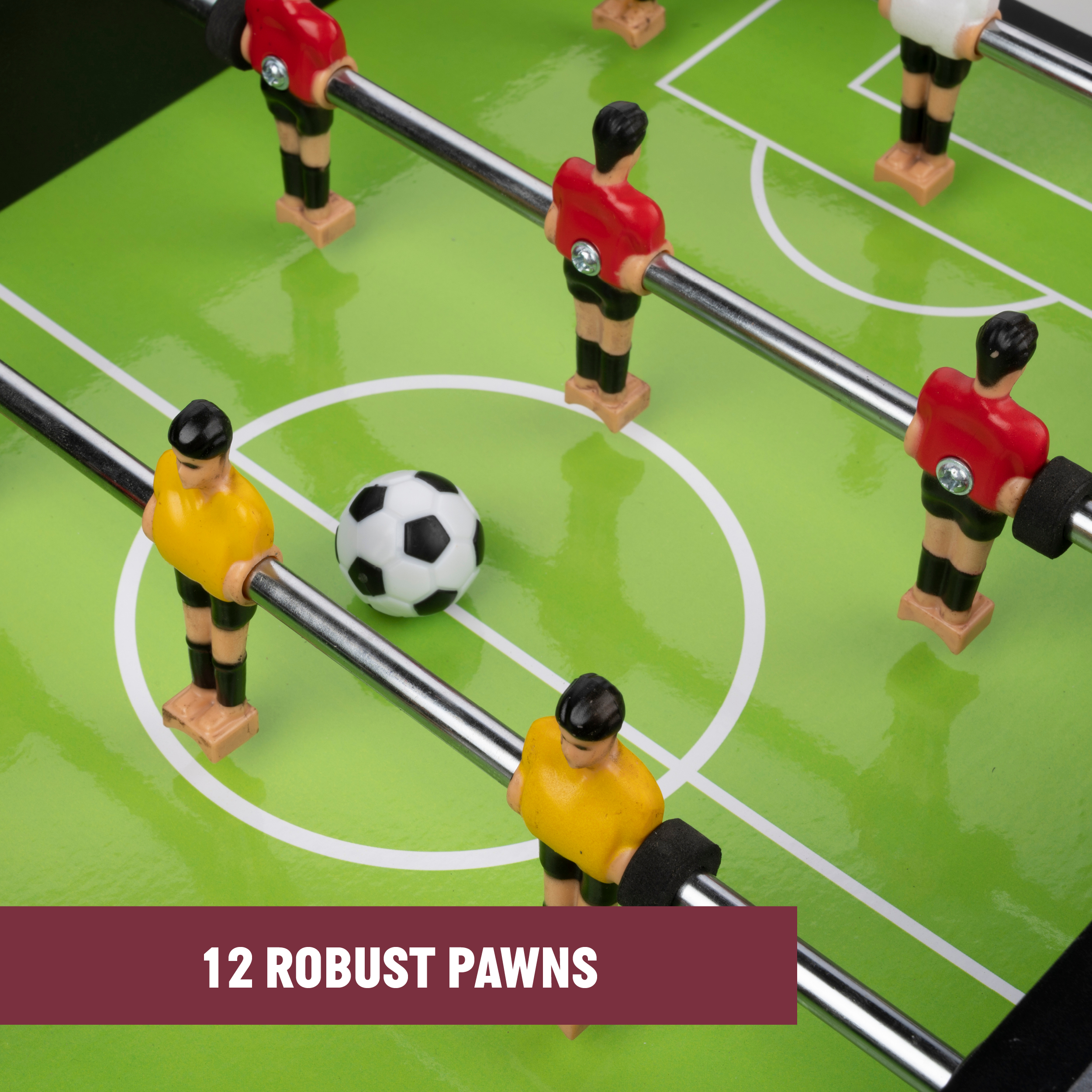 Foosball table with green field, players in red and yellow, and a black and white ball.