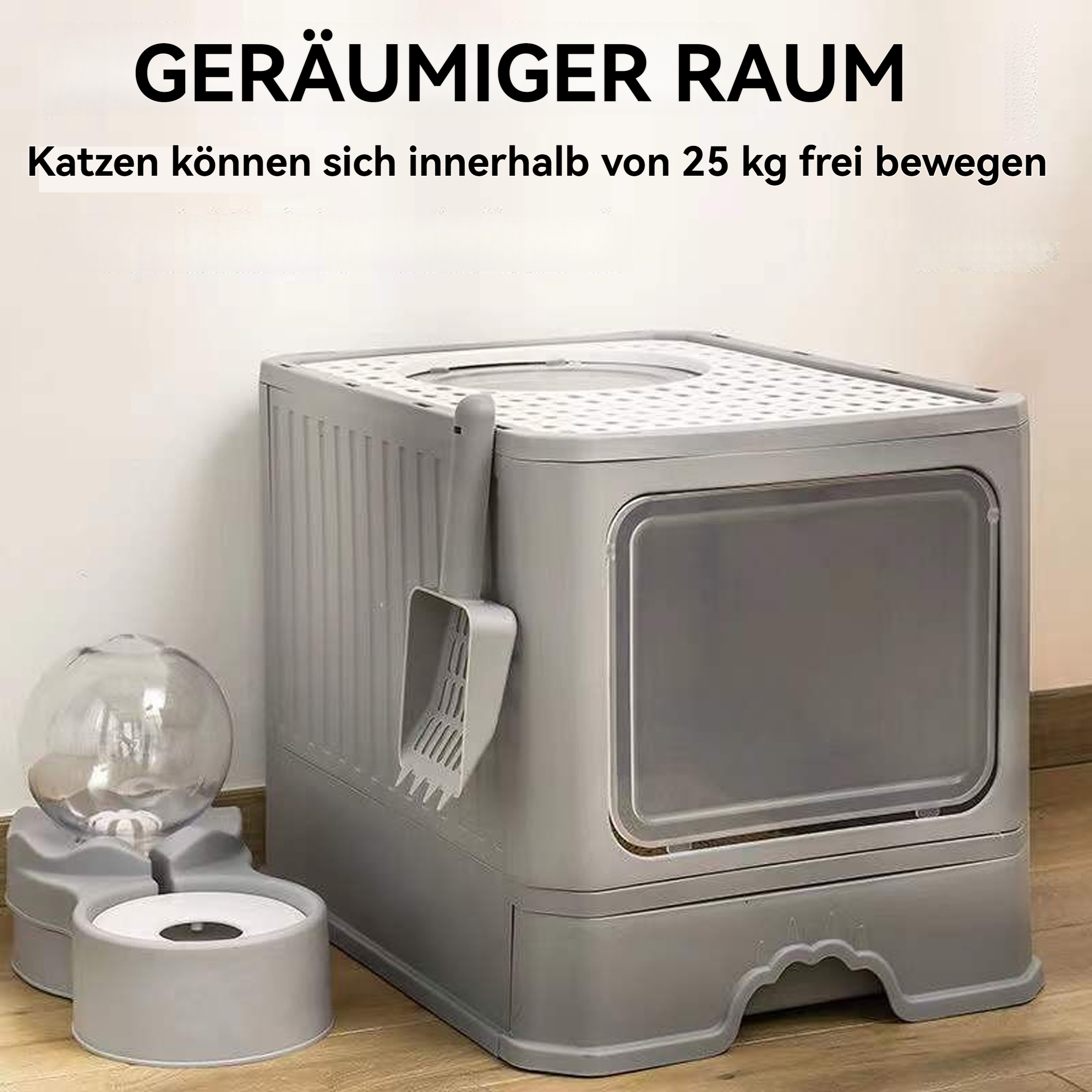 Eine graue Katzentoilette neben einem Futter- und Wassernapf. Eine Schaufel und ein Schaufelhalter sind ebenfalls sichtbar.