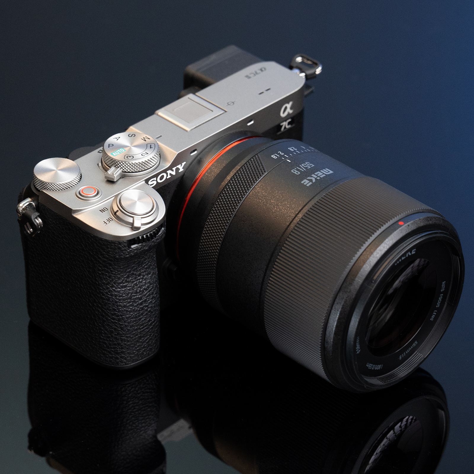 Sony Kamera mit Objektiv auf dunkler, reflektierender Oberfläche.