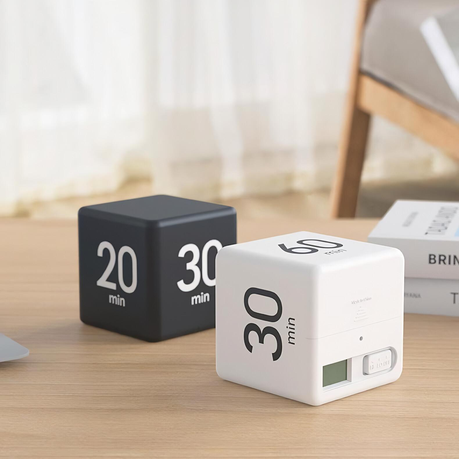 Zwei Würfel-Timer. Einer schwarz mit 20 Min., der andere weiß mit 30 Min., mit einem kleinen Bildschirm.