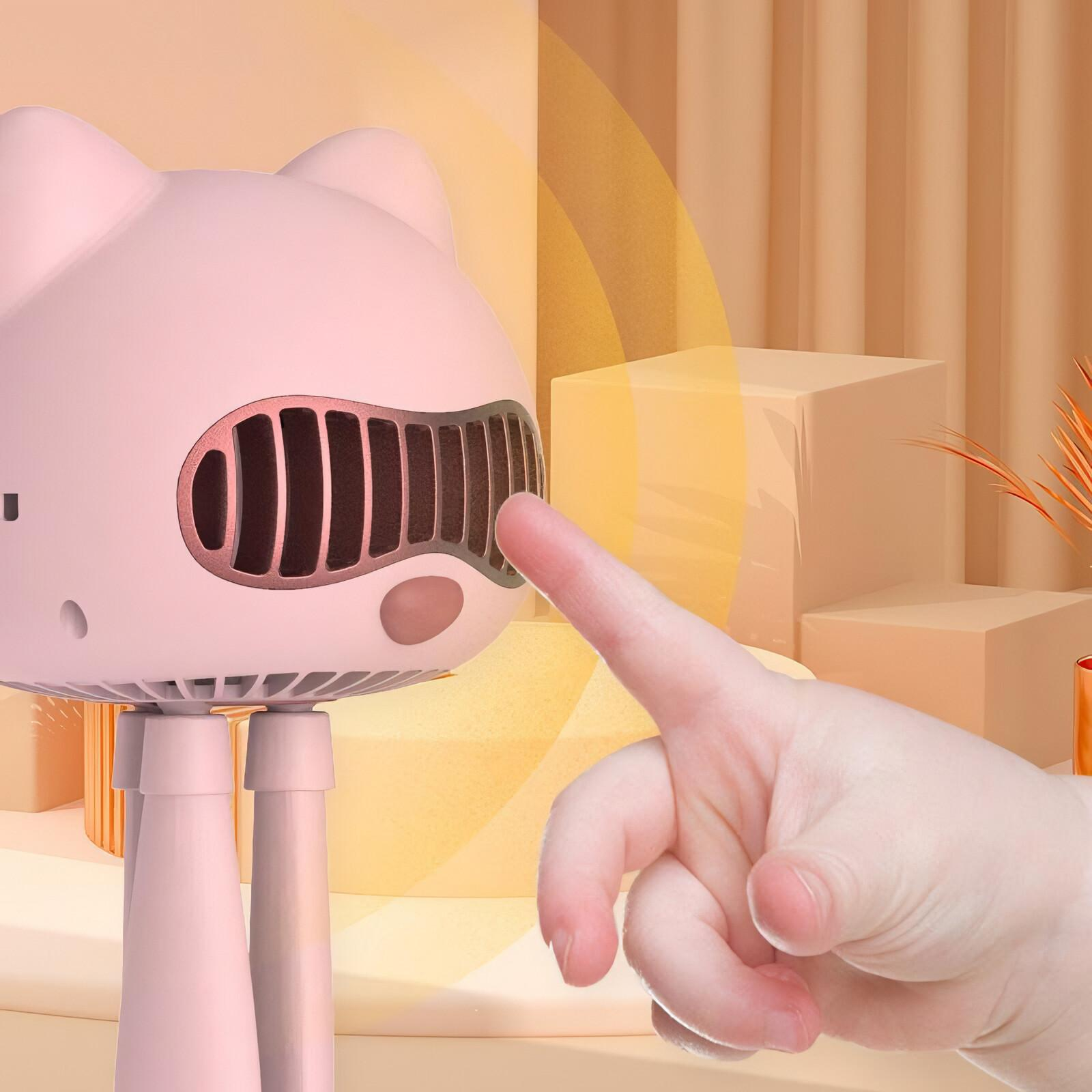 Pinker katzenförmiger Ventilator mit einem Finger, der das Gitter berührt, vor weichem Hintergrund.