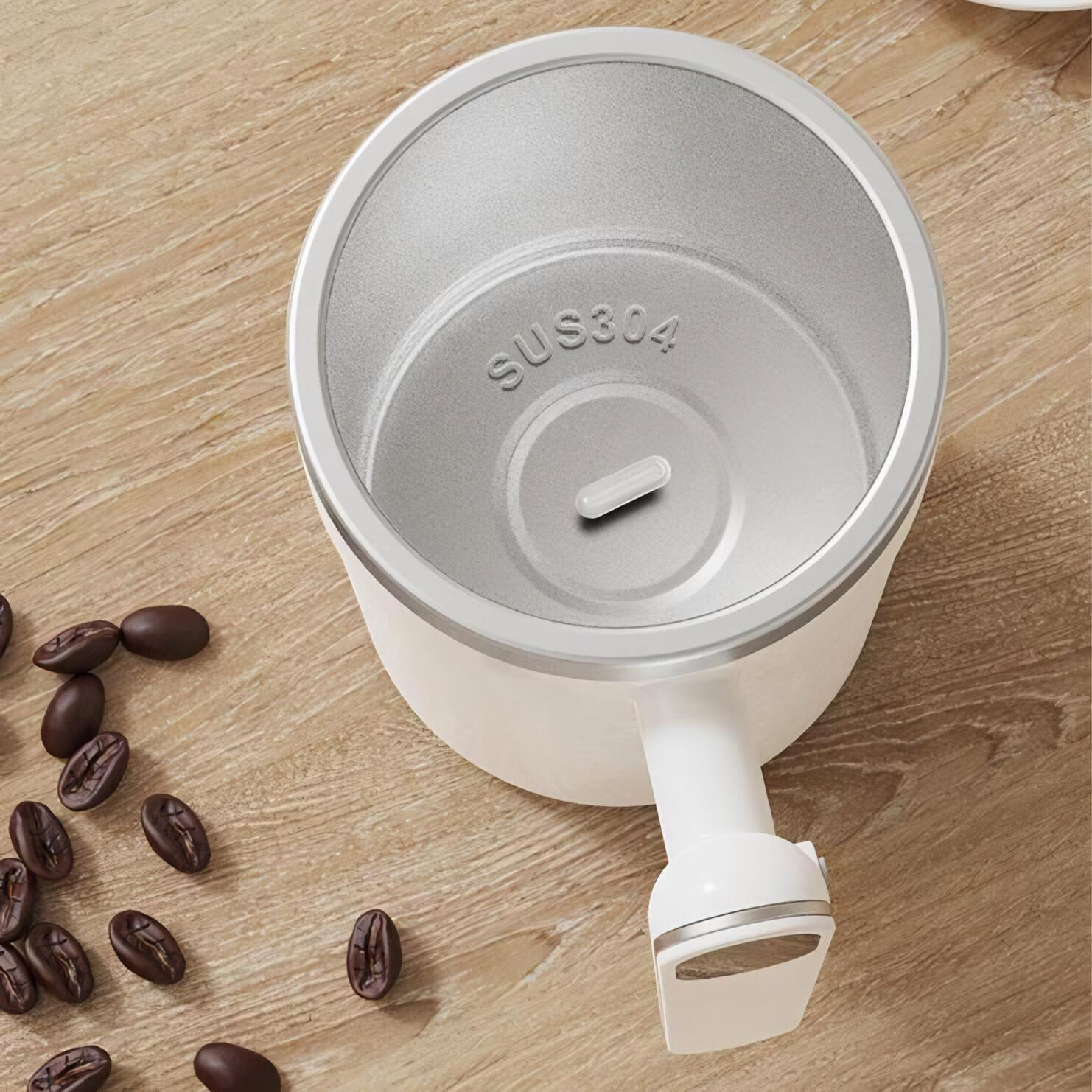 Eine weiße Tasse auf einem Holztisch mit Kaffeebohnen. Die Tasse ist offen und zeigt das Innere.