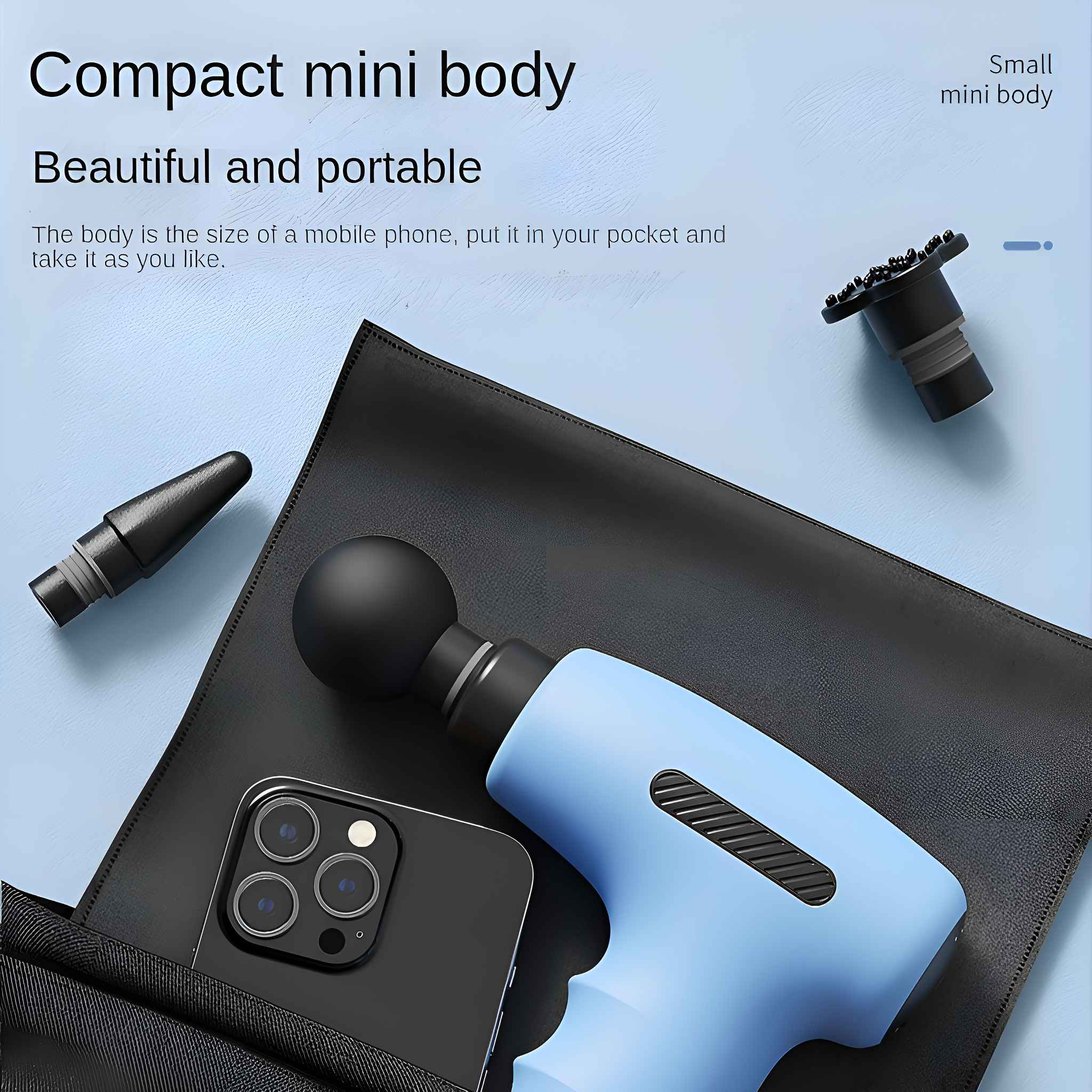 Blaue Massagepistole mit schwarzen Aufsätzen, einem Telefon und einer schwarzen Tasche auf schwarzem Untergrund.